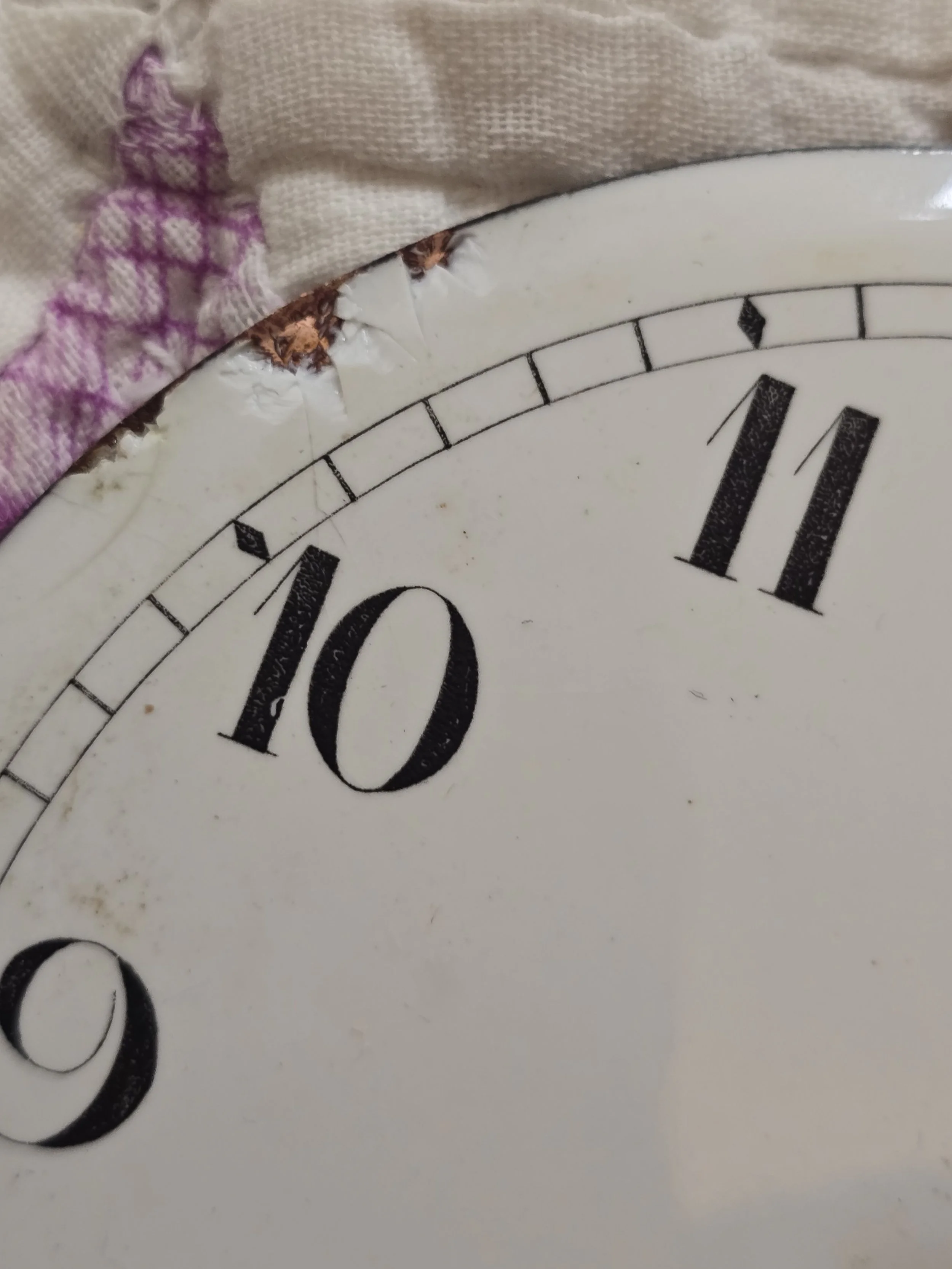 Detail of antique enamel clock dial with chips, patina and original minute markers.