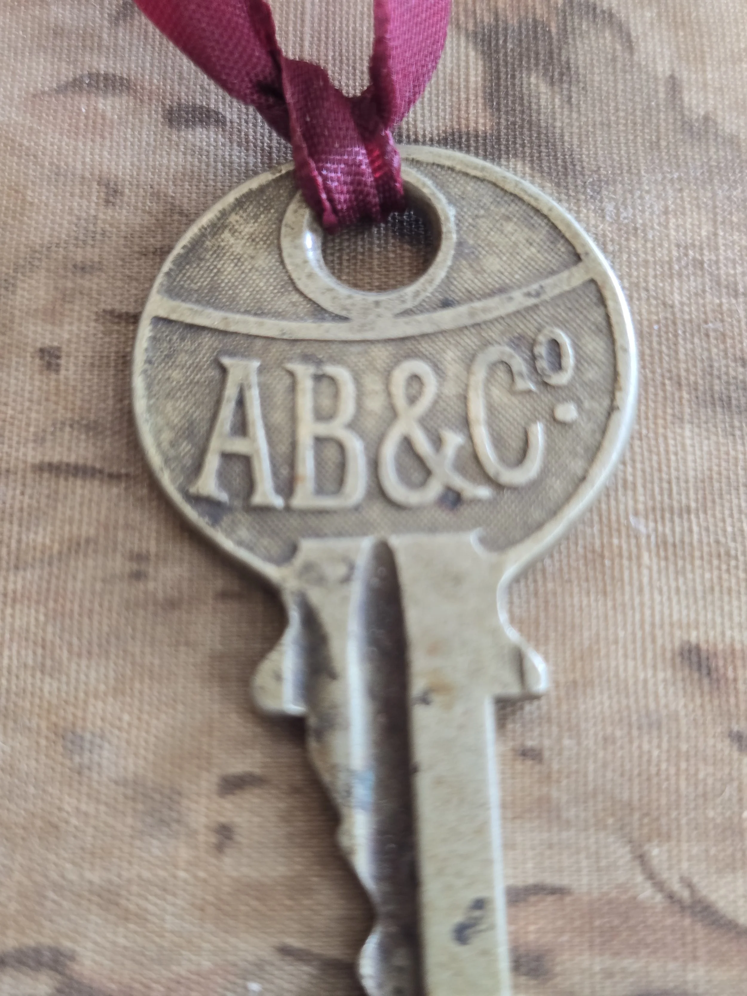 Close-up of AB&C lettering on aged metal key.