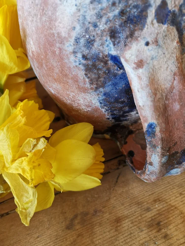 Handle detail of antique French terracotta pitcher showing textured glaze and wear