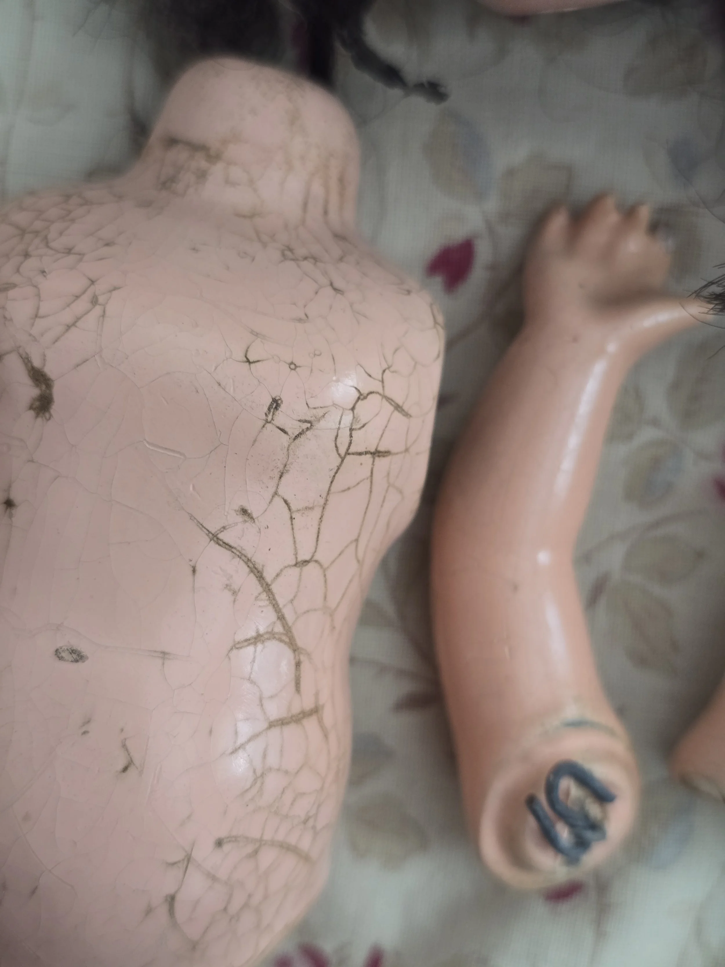 Composition doll body showing age crazing and wear