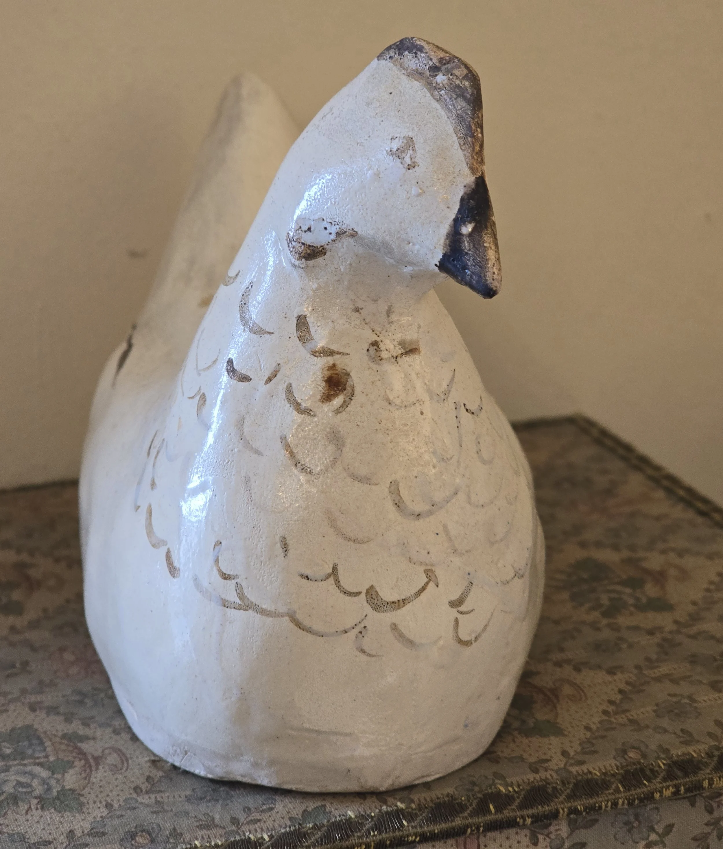 Detail of the hen's tail showing faded white surface and black painted wing lines.