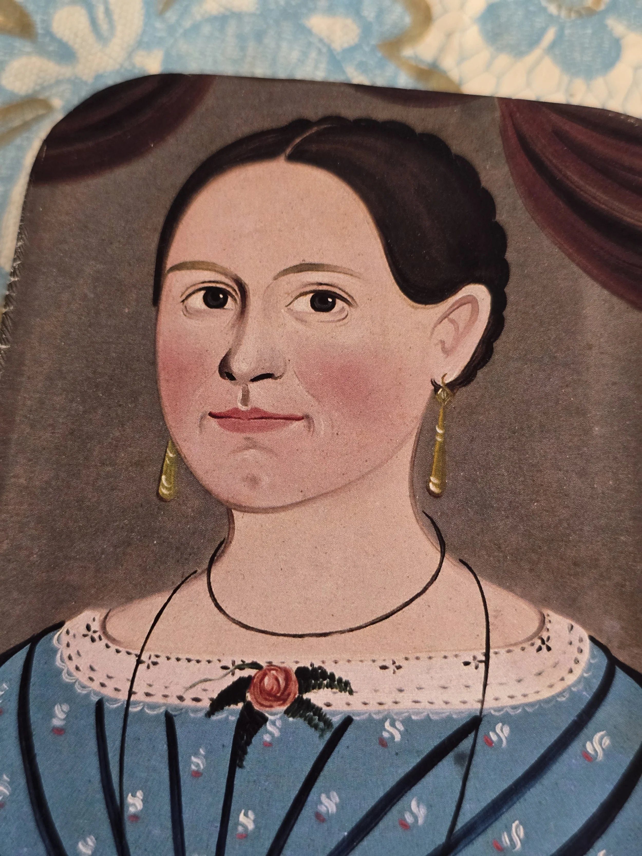 Aged metal tin with portrait illustration of a woman in a blue dress.