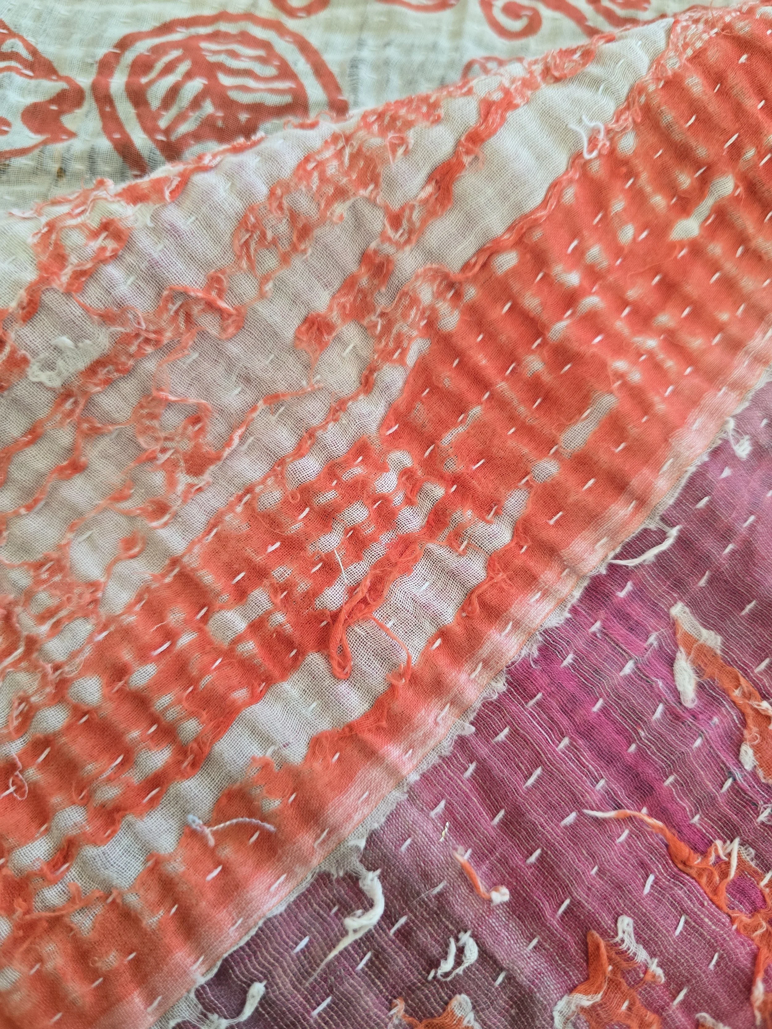 Hand-stitched vintage kantha fragment featuring floral motifs, fish designs and visible repair stitches.