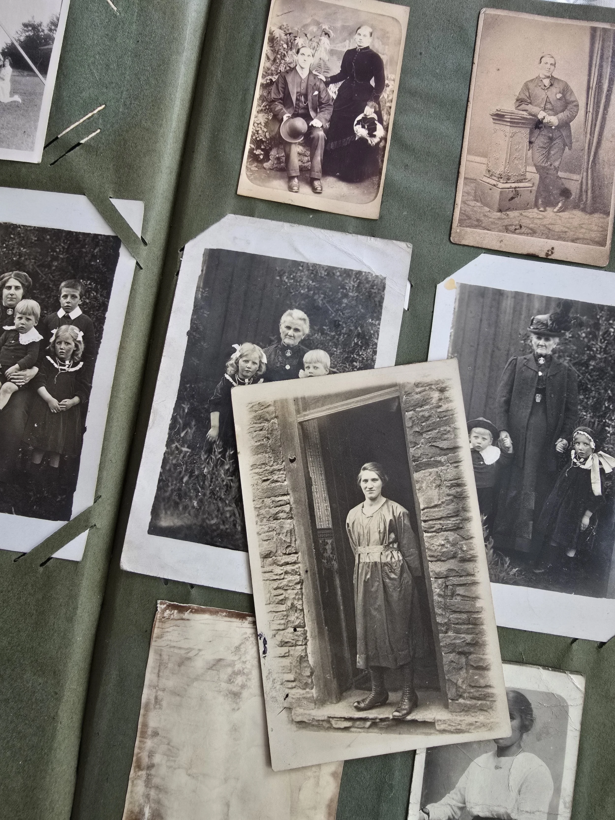 Antique family photographs with woman standing in a doorway, rustic stone background