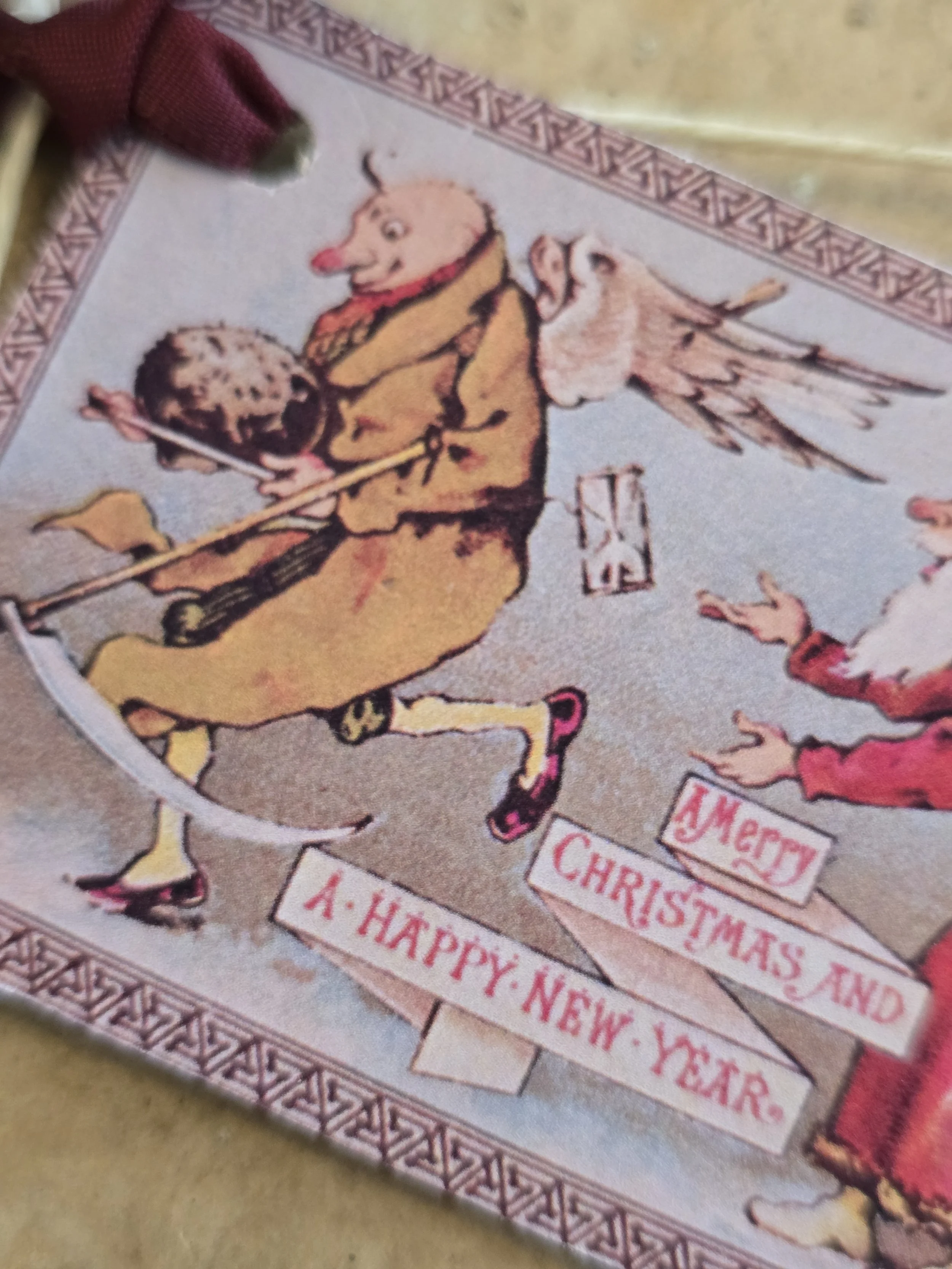 Close-up of printable Christmas tag showing a whimsical antique illustration of a pig running away with a Christmas pudding.
