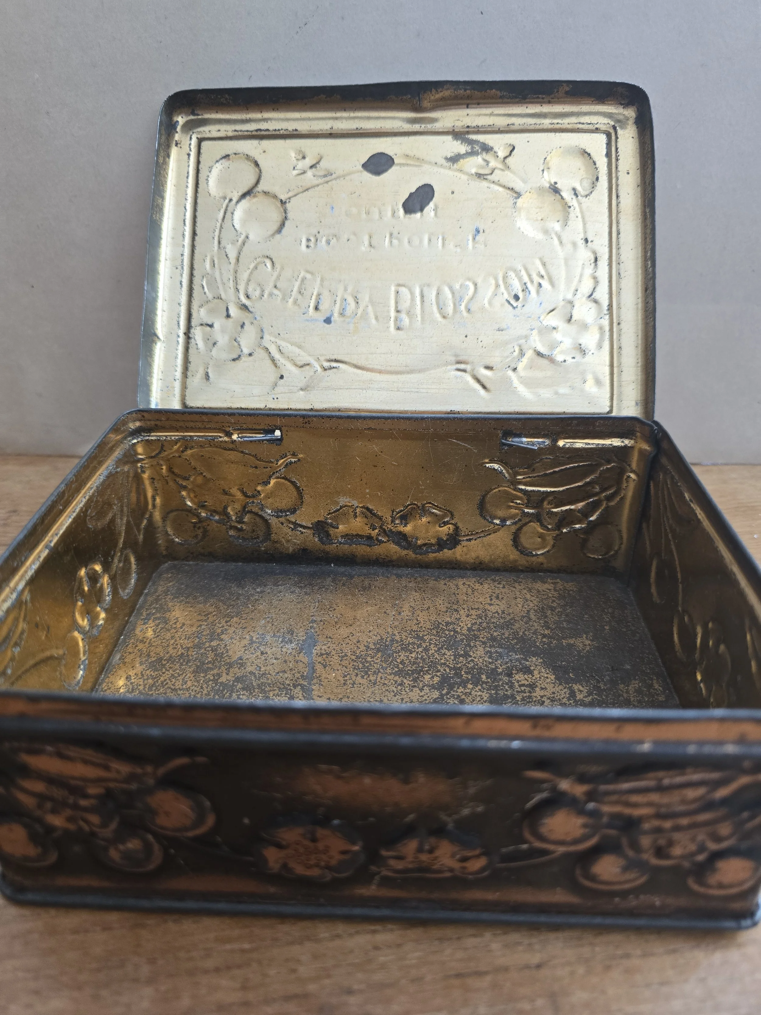 Patinated metal box with embossed cherries and blossoms.