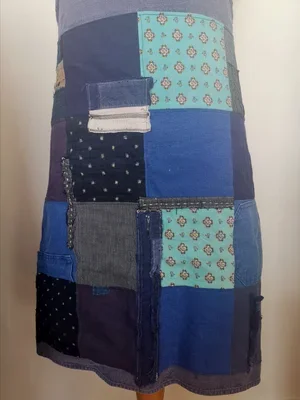 Closeup of apron top section with indigo bleu de travail fabric and patterned patchwork