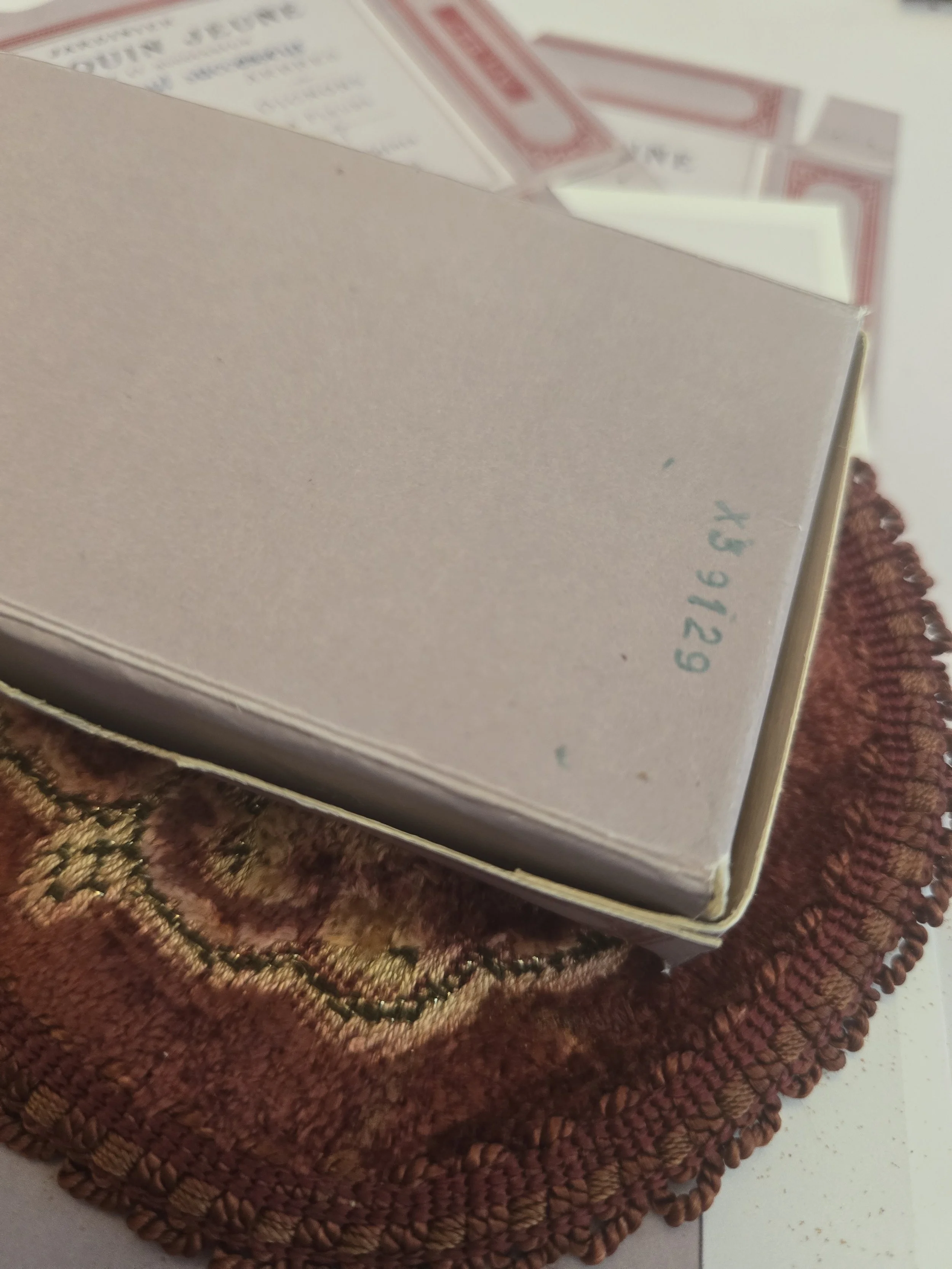 Underside of handmade Pomme de Jour box showing the original character and markings of the vintage French card stock.