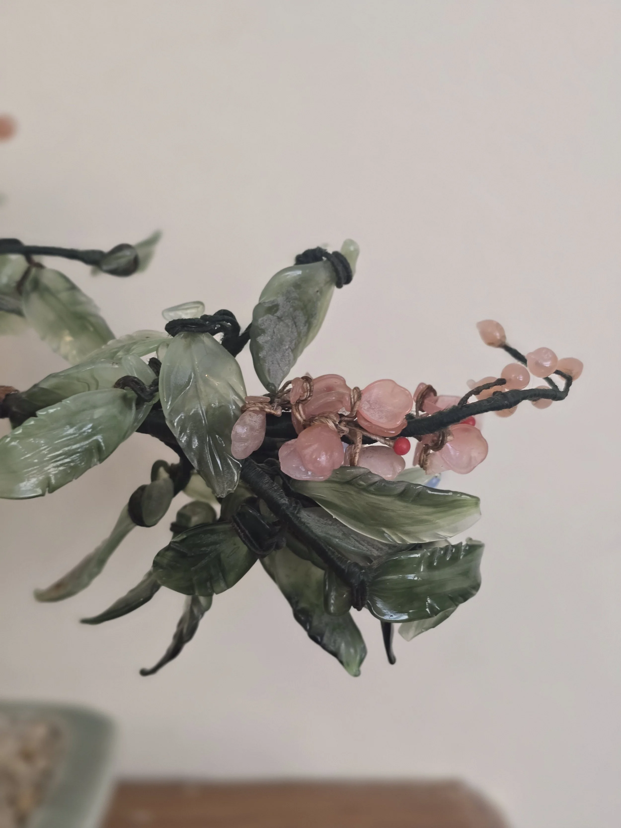 Close view of hand-crafted glass leaves and floral detailing on vintage bonsai tree