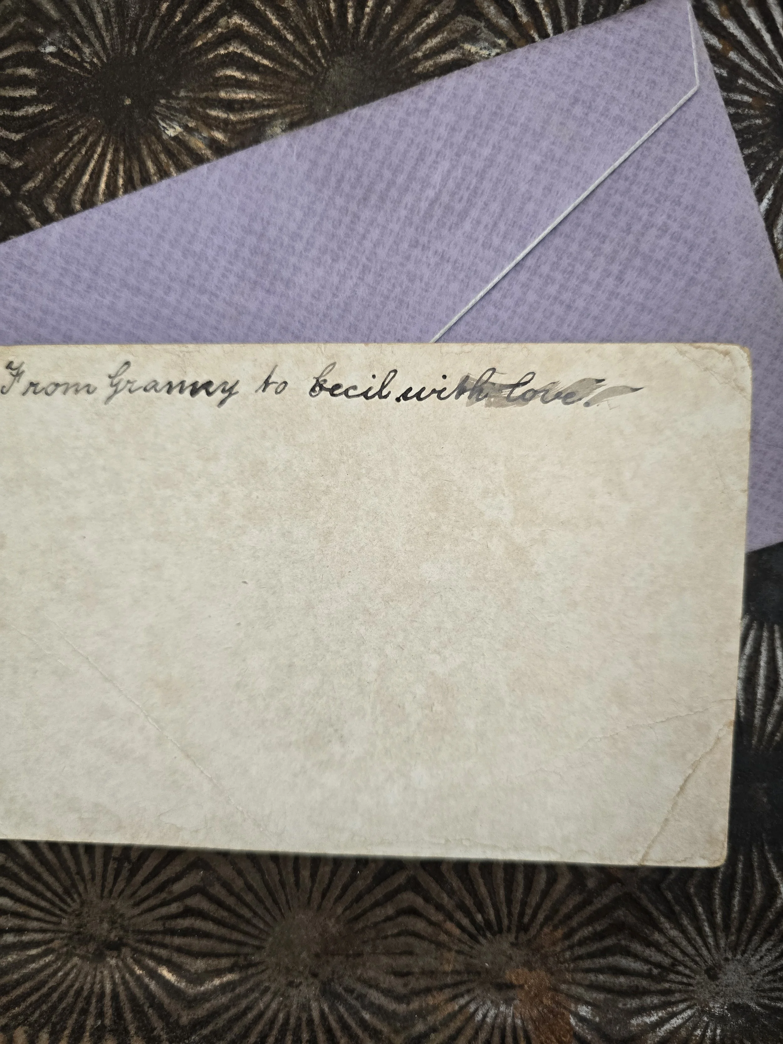 Reverse of vintage greeting card with handwritten inscription and signs of age and wear.