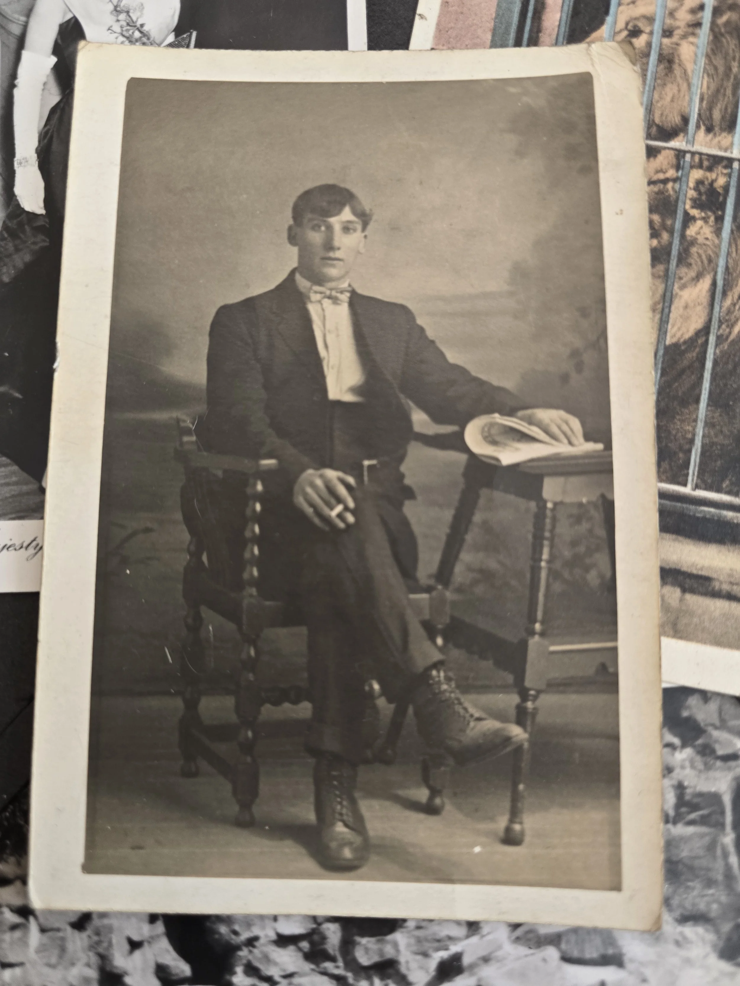 Original c.1930 British studio photograph of a young man seated in a suit and bow tie.