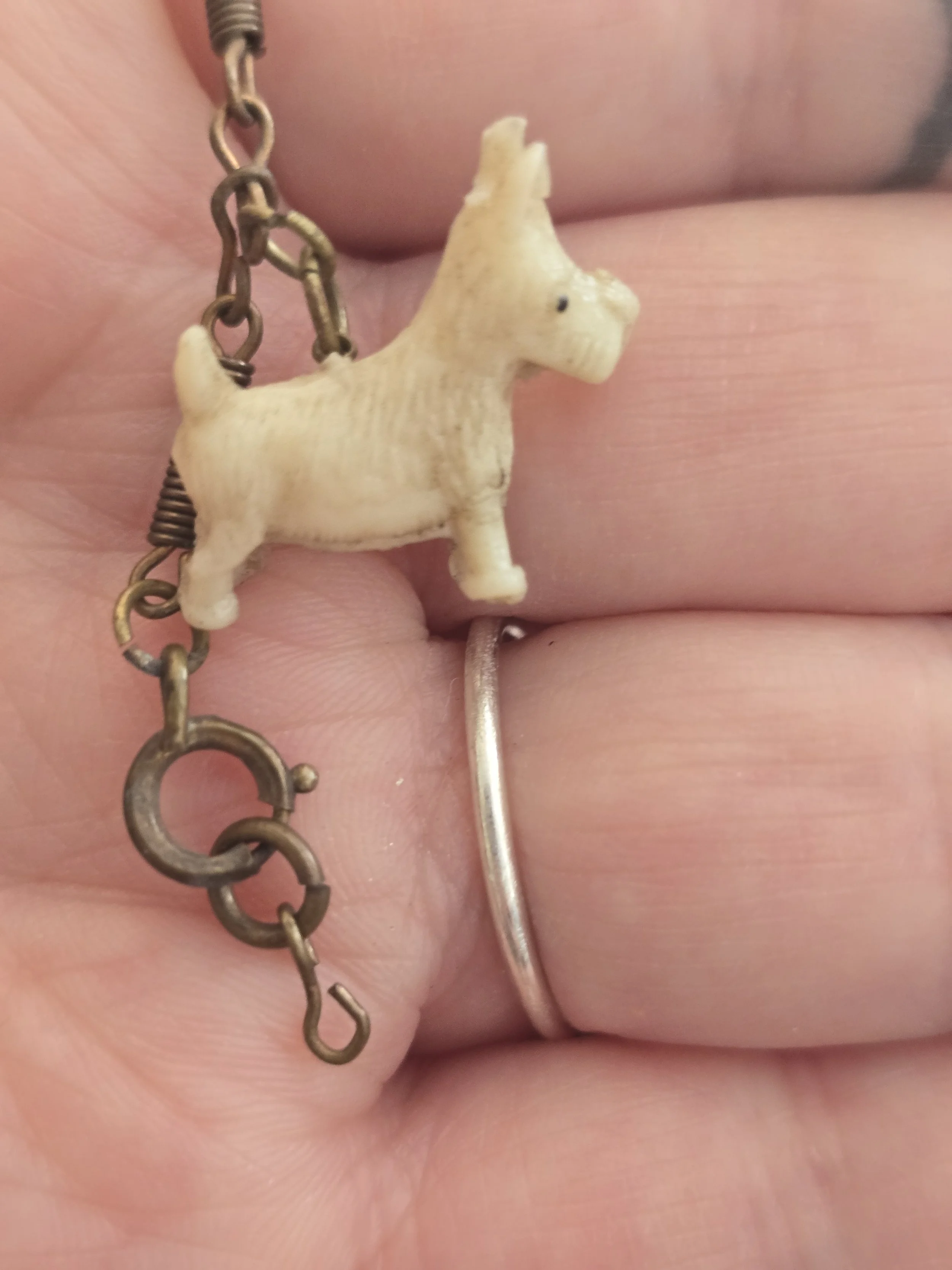 Mid-century novelty charm bracelet with playful terrier dog figures and brass-toned fittings.