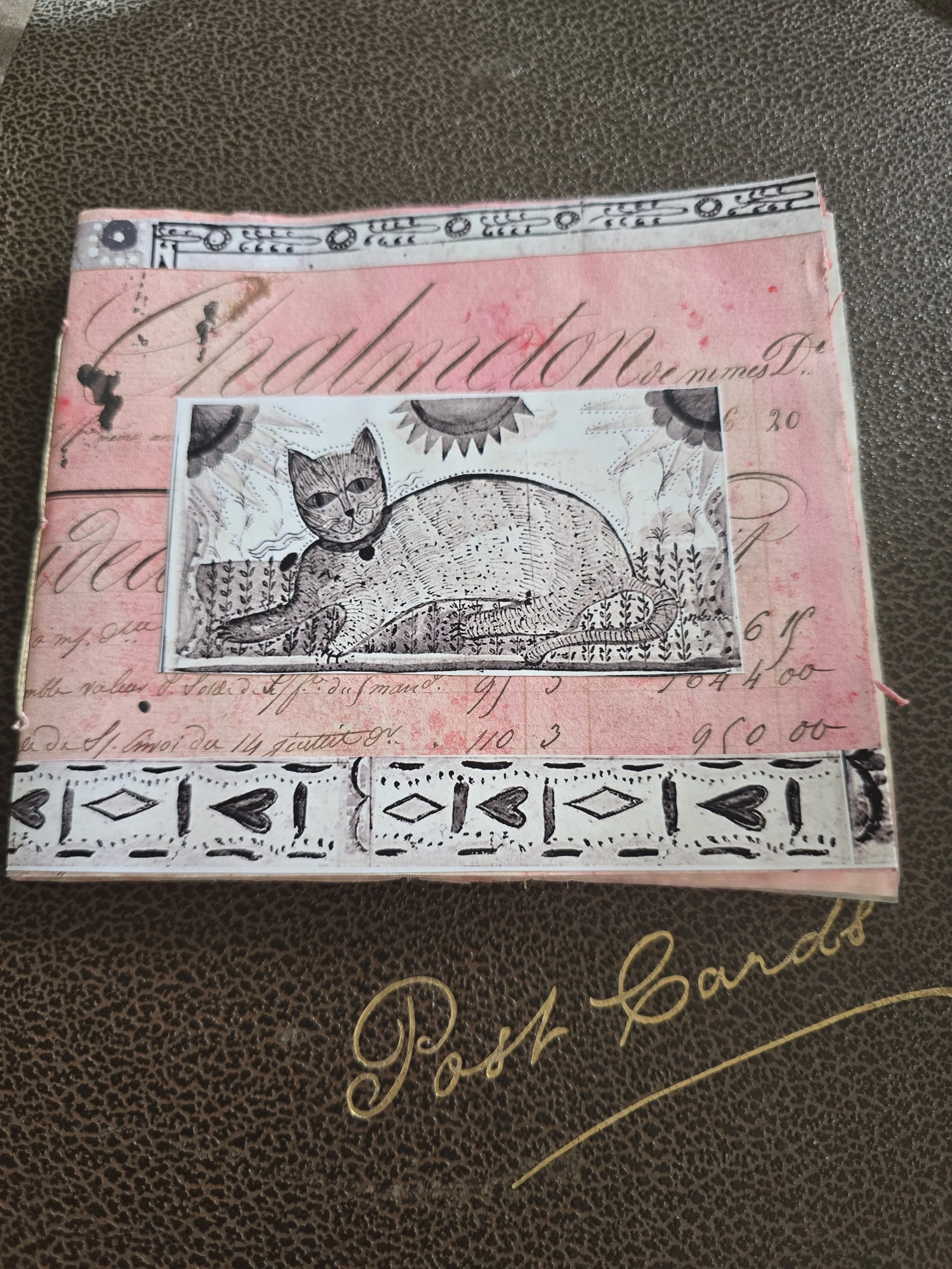 Handmade journal with antique French ledger paper and primitive cat illustration on the cover.