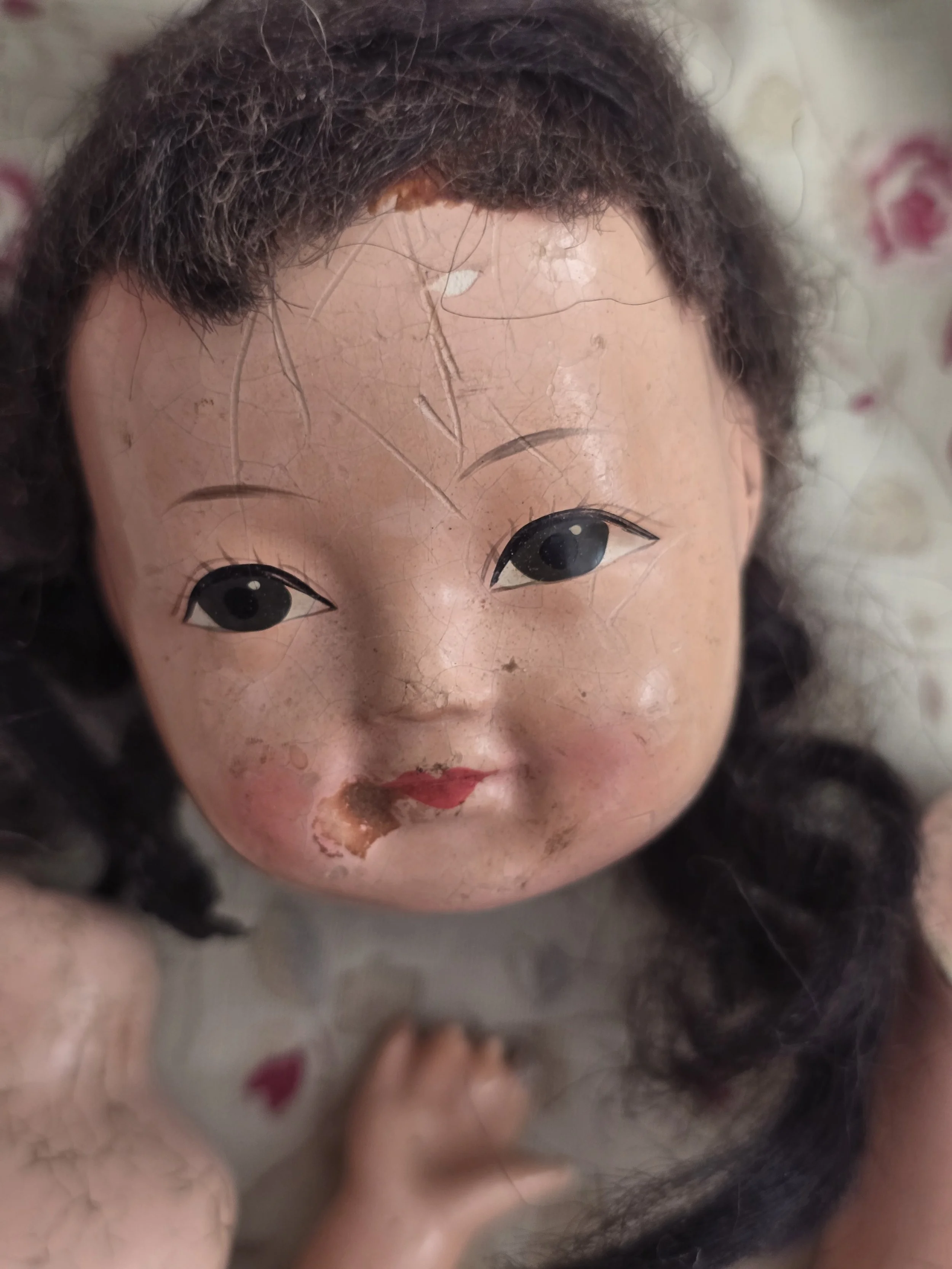 Close-up of vintage doll face with original dark hair.