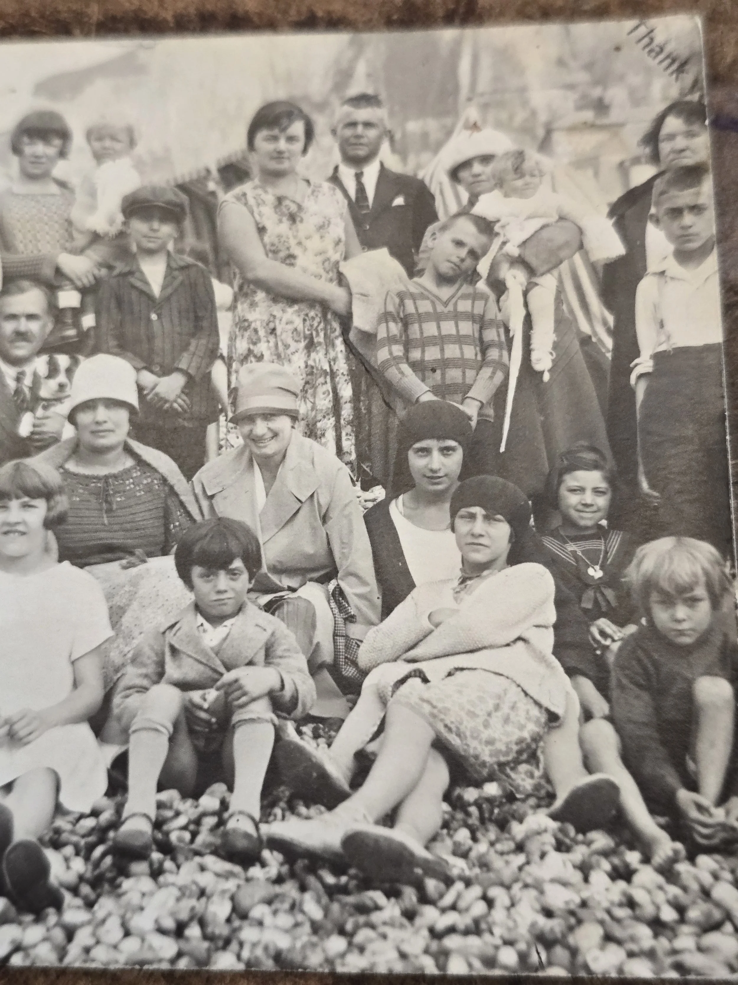 Close view of adults and children wearing period clothing in a French seaside scene.