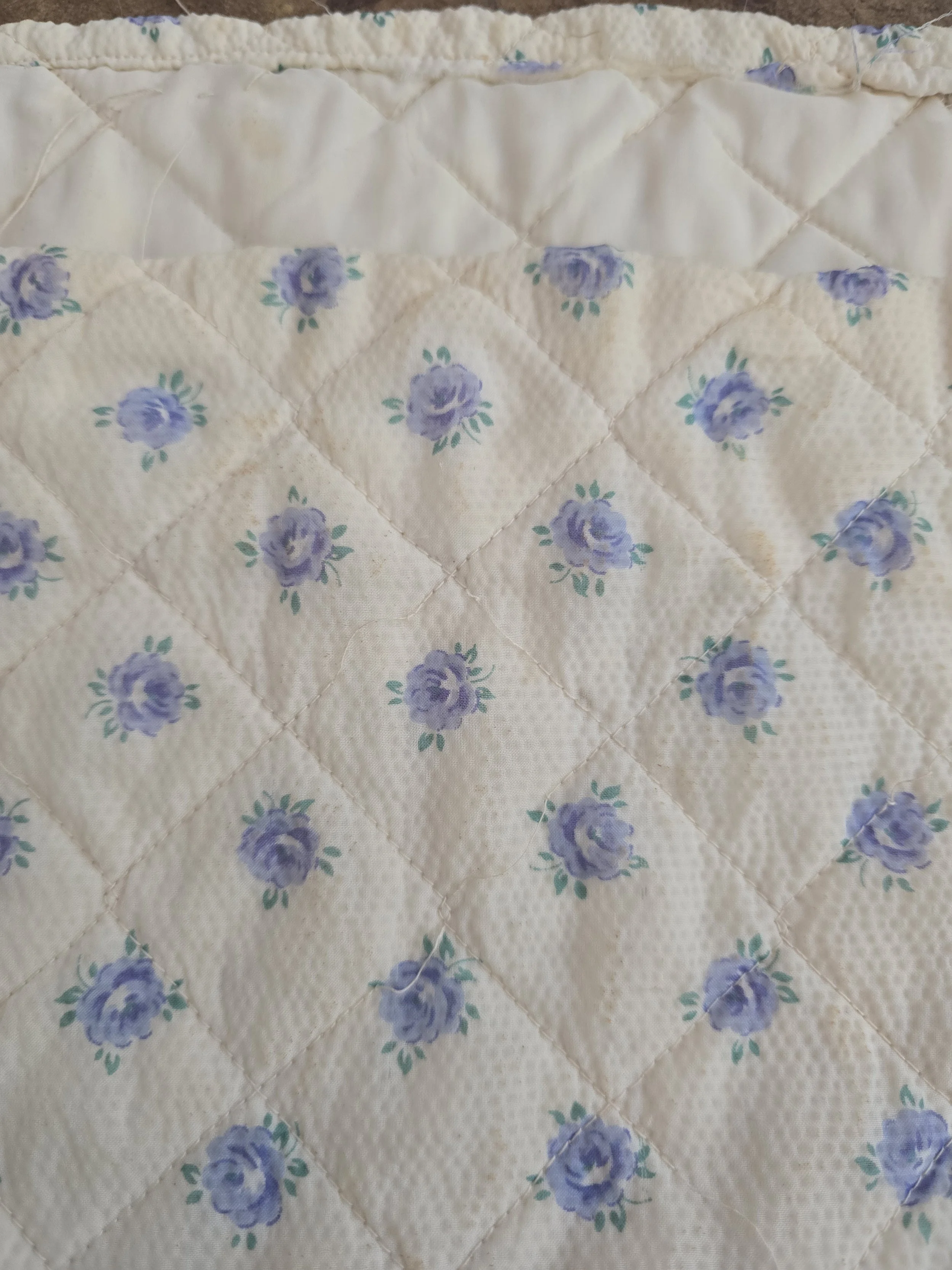 Small floral doll's sheet in faded pink cotton fabric.