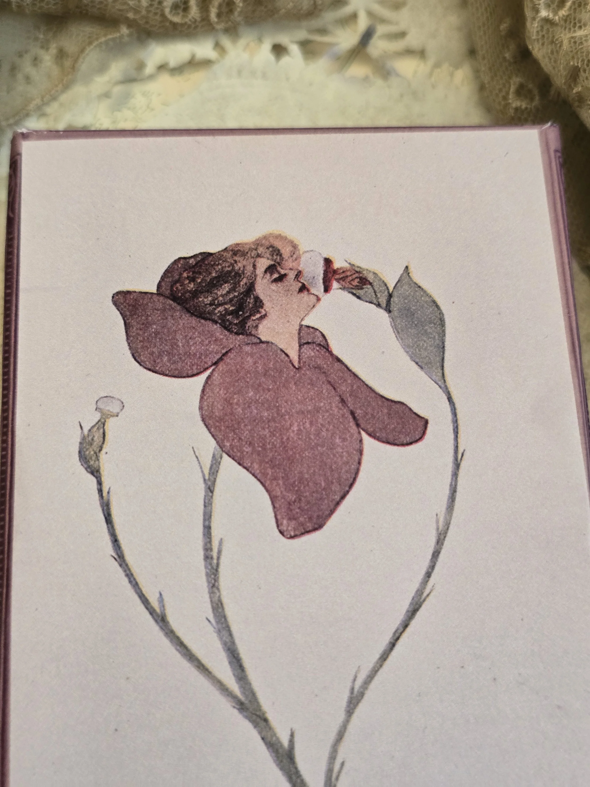 Side view of handmade Puff Blossom keepsake box showing mauve edging and vintage French label detail.
