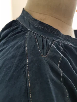 Shoulder pleat detail showing hand stitches on antique biaude.