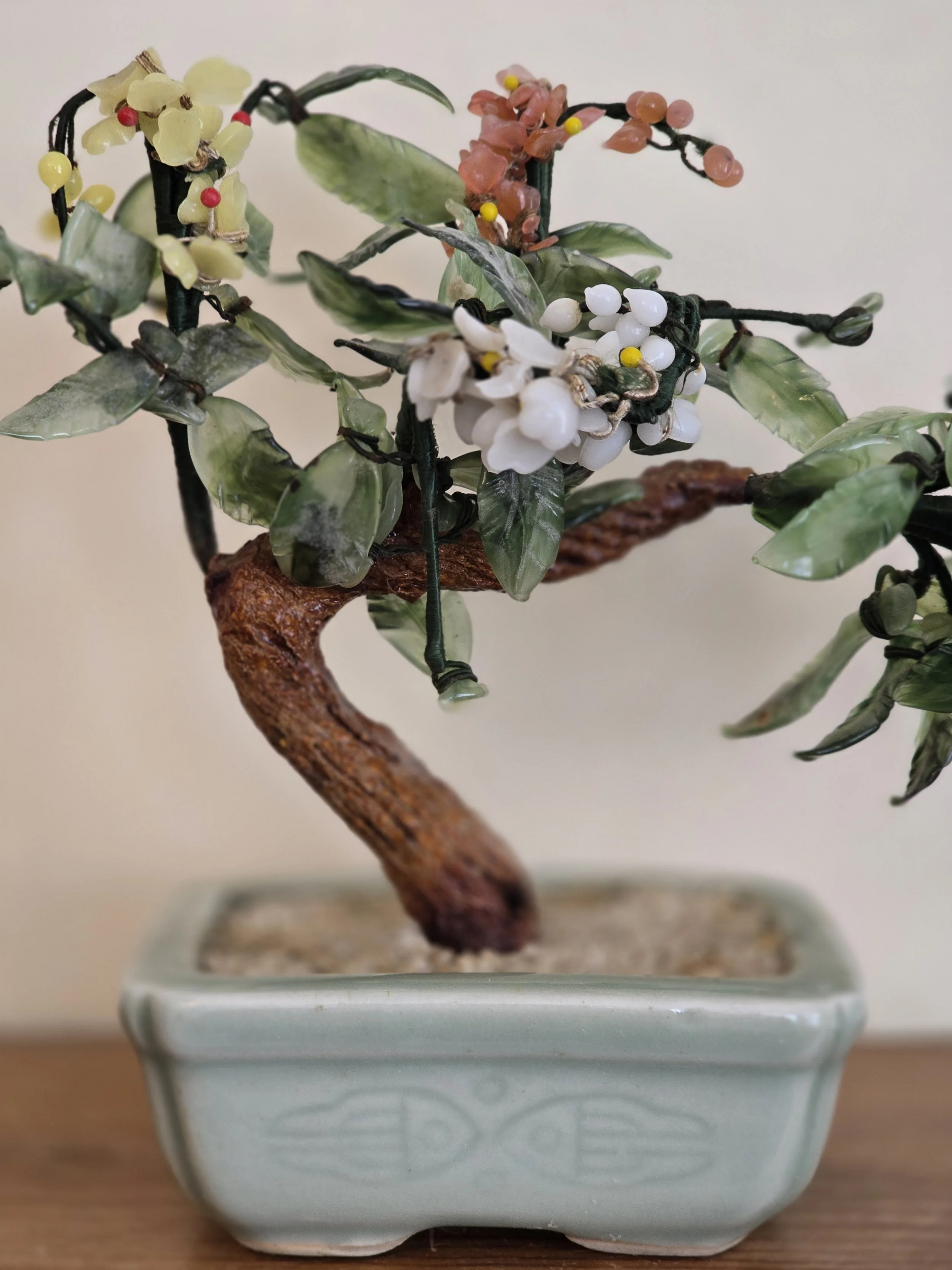 Decorative miniature bonsai tree with translucent glass blossoms and twisted trunk