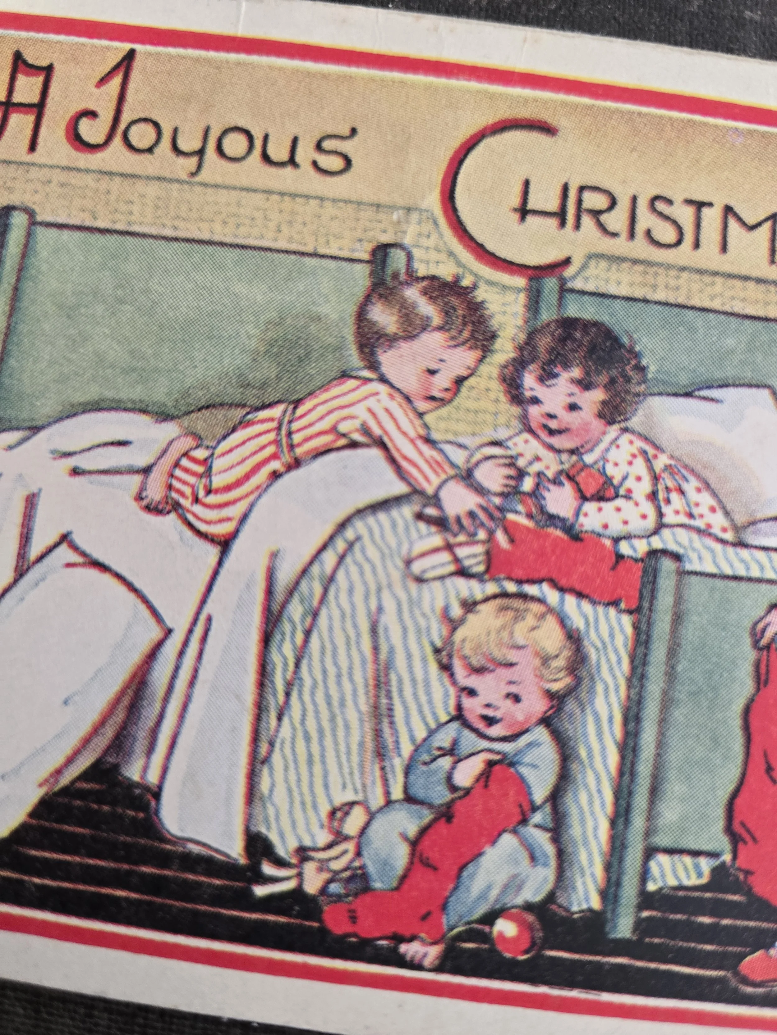 Detail of a child in red striped pyjamas blowing a trumpet beside a Christmas stocking and toy drum.