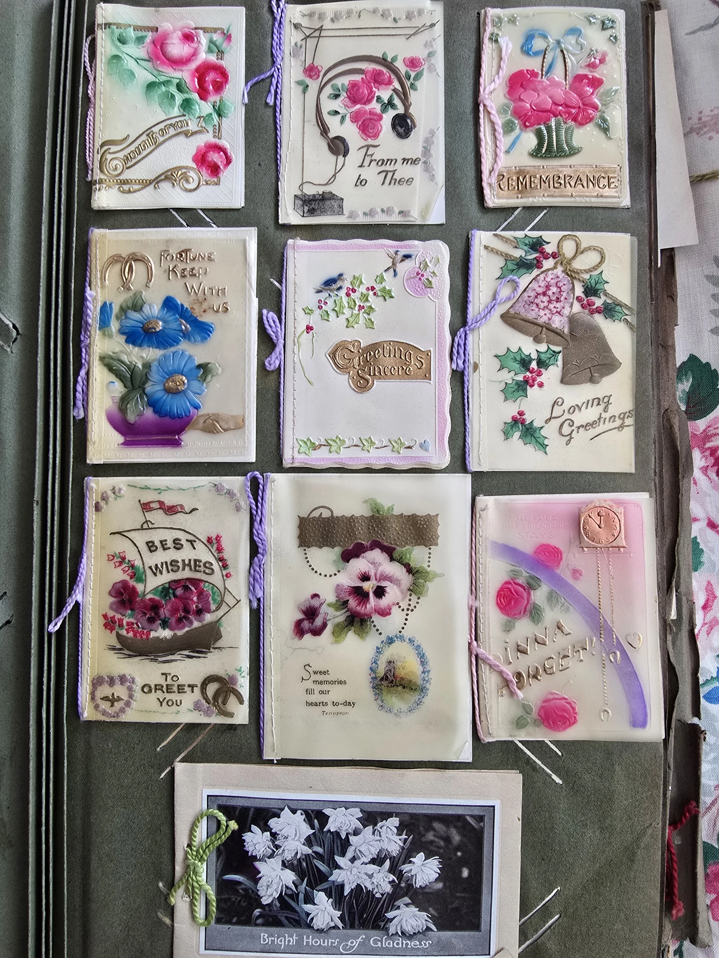 Antique postcard album page with embossed floral greeting cards, early 20th century