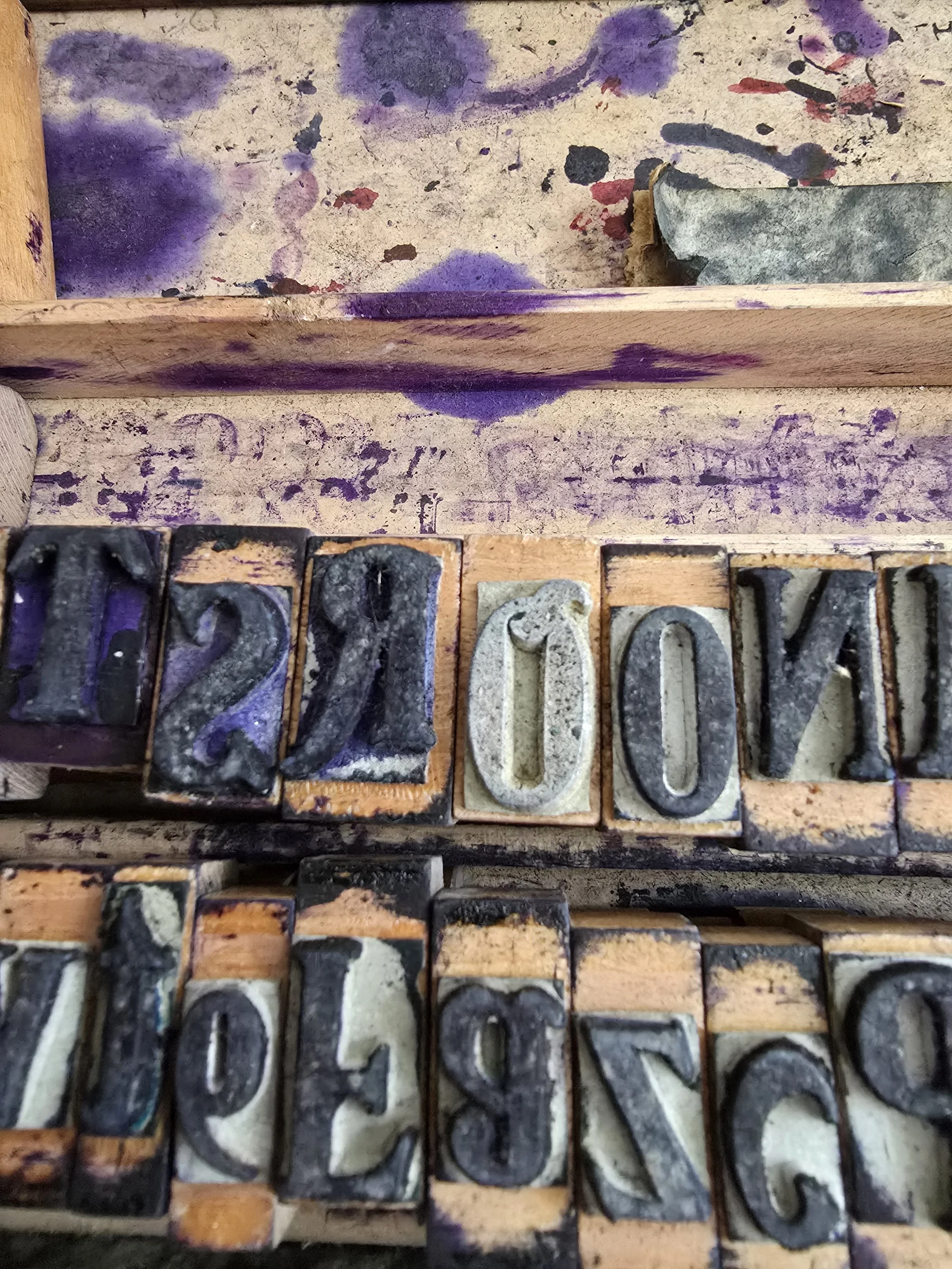 Row of wood-mounted rubber stamp letters with age and patina.