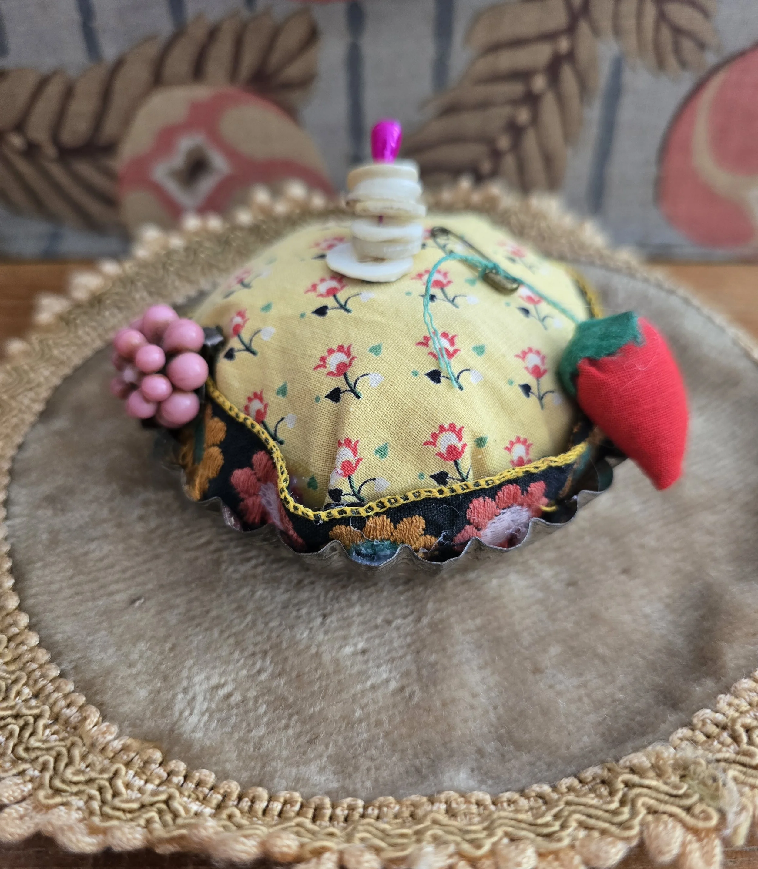Studio Made French tart pin cushion in a vintage metal tart mould displayed on a vintage velvet dish