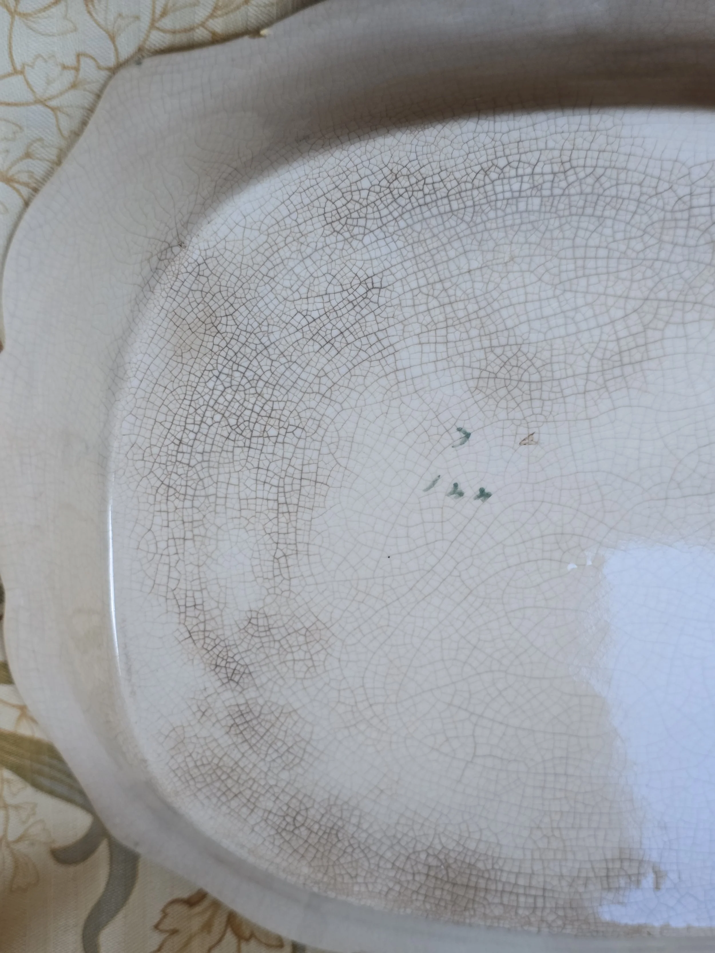 Detail of petrol blue glazed border, floral decoration and raised white flowers on vintage ceramic tray.