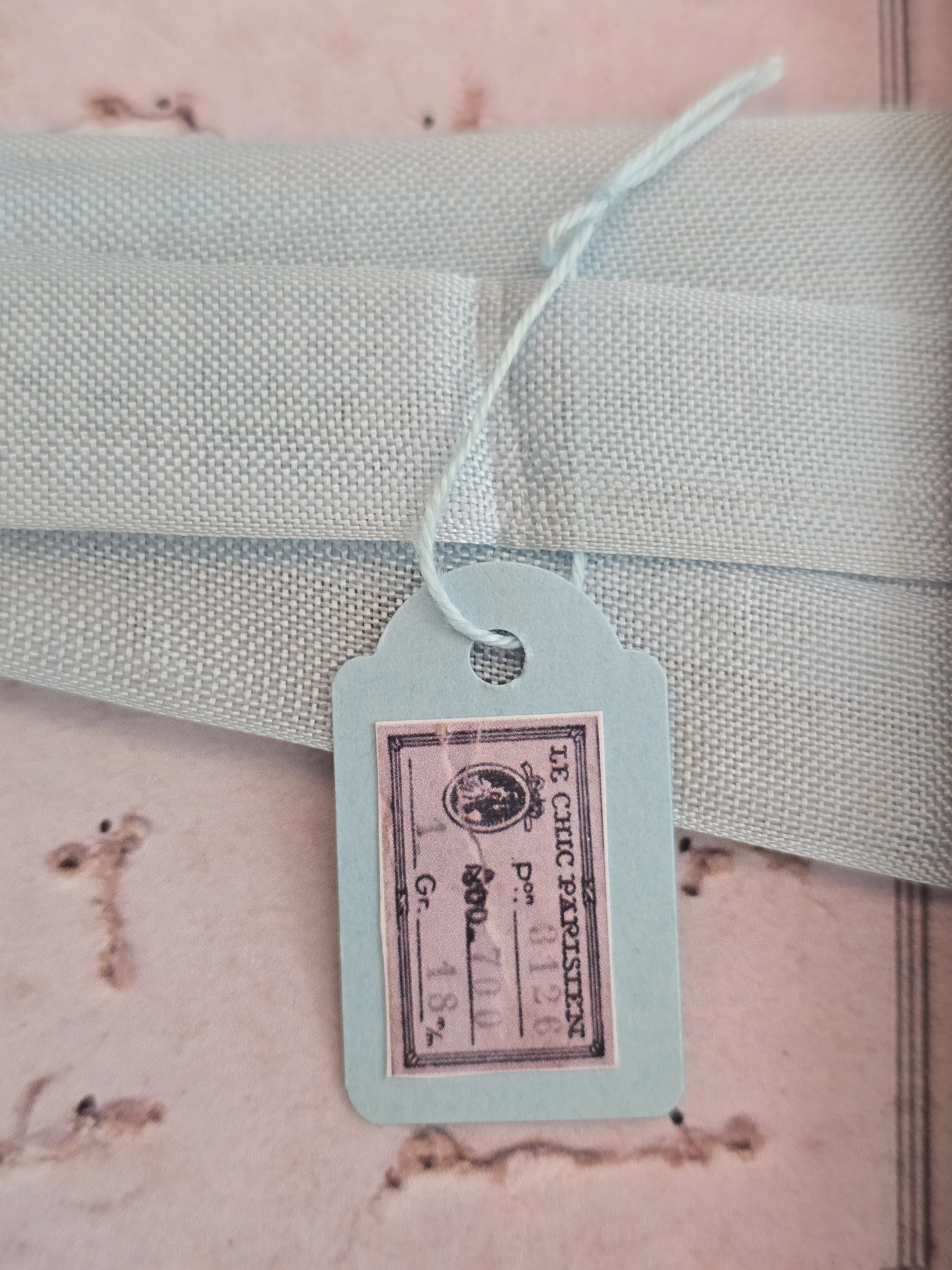 Pale blue vintage French ribbon presented on a pink vintage style haberdashery card.