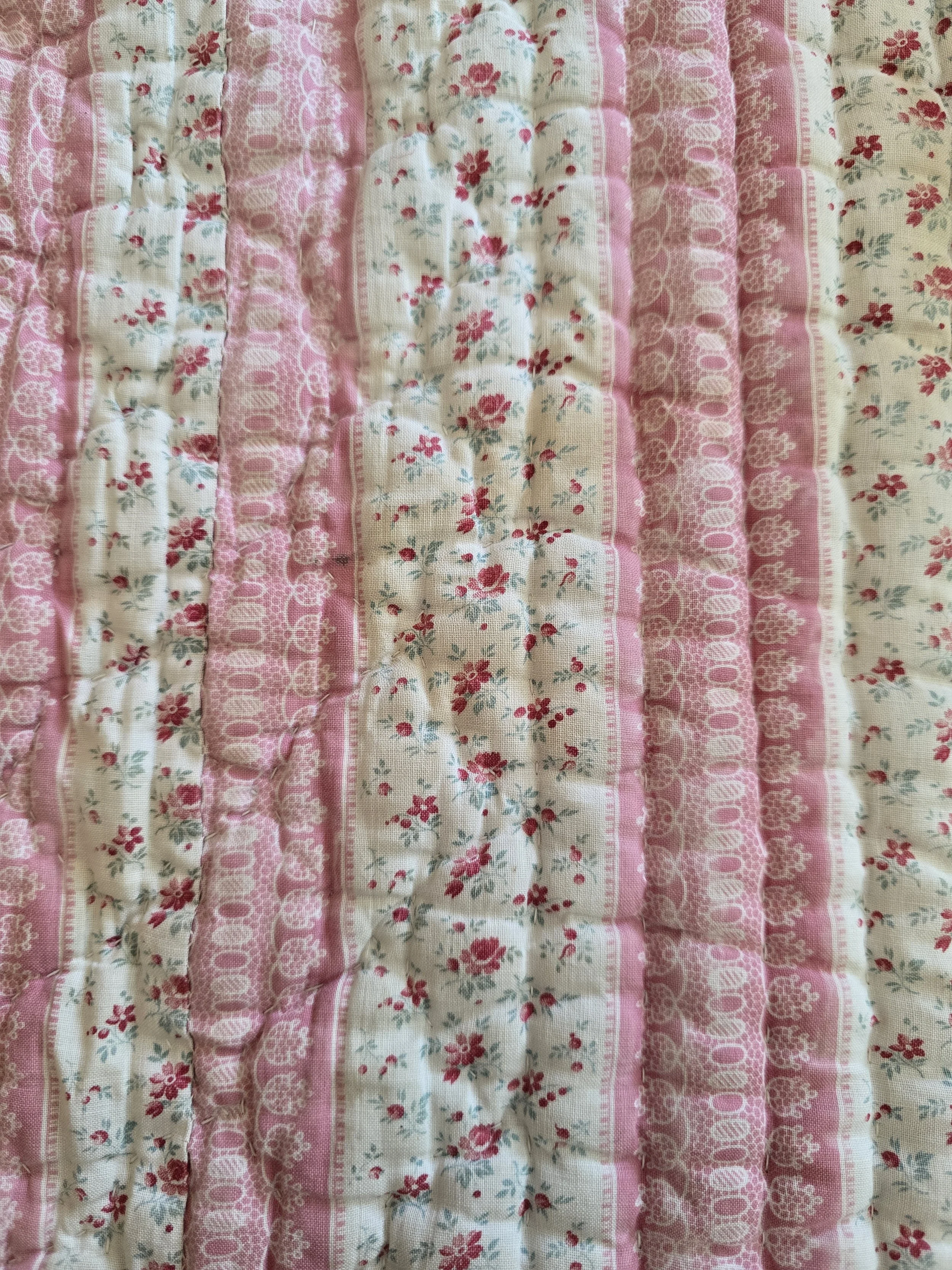 Vintage French quilted textile fragment with pink rosebud floral stripes and soft quilting.