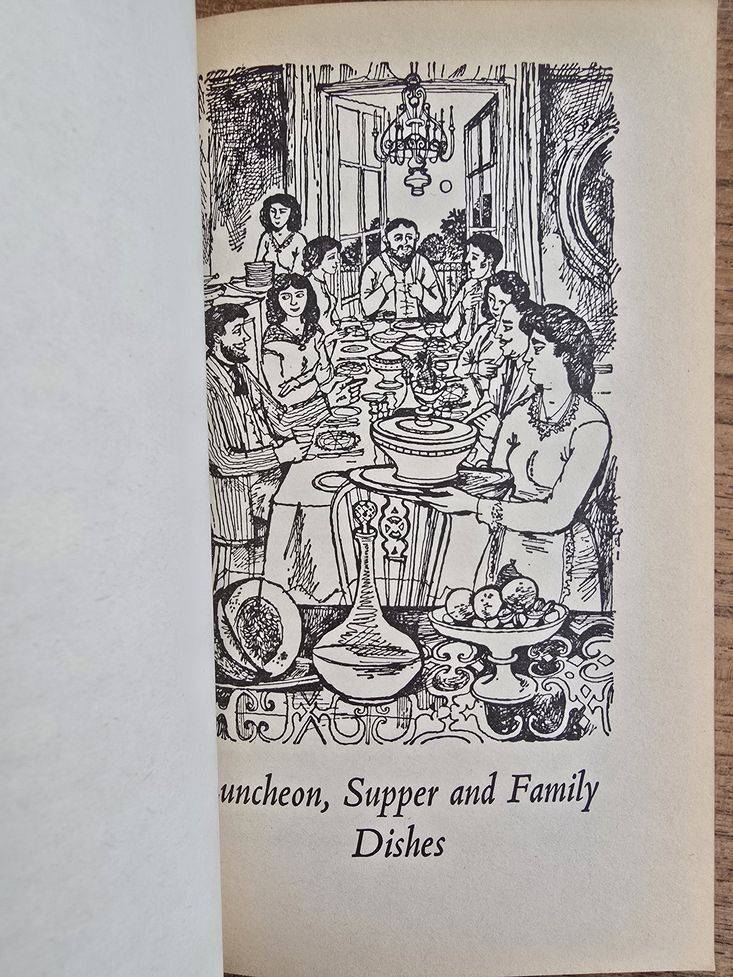 Monochrome illustration of a French kitchen and town scene with cookware
