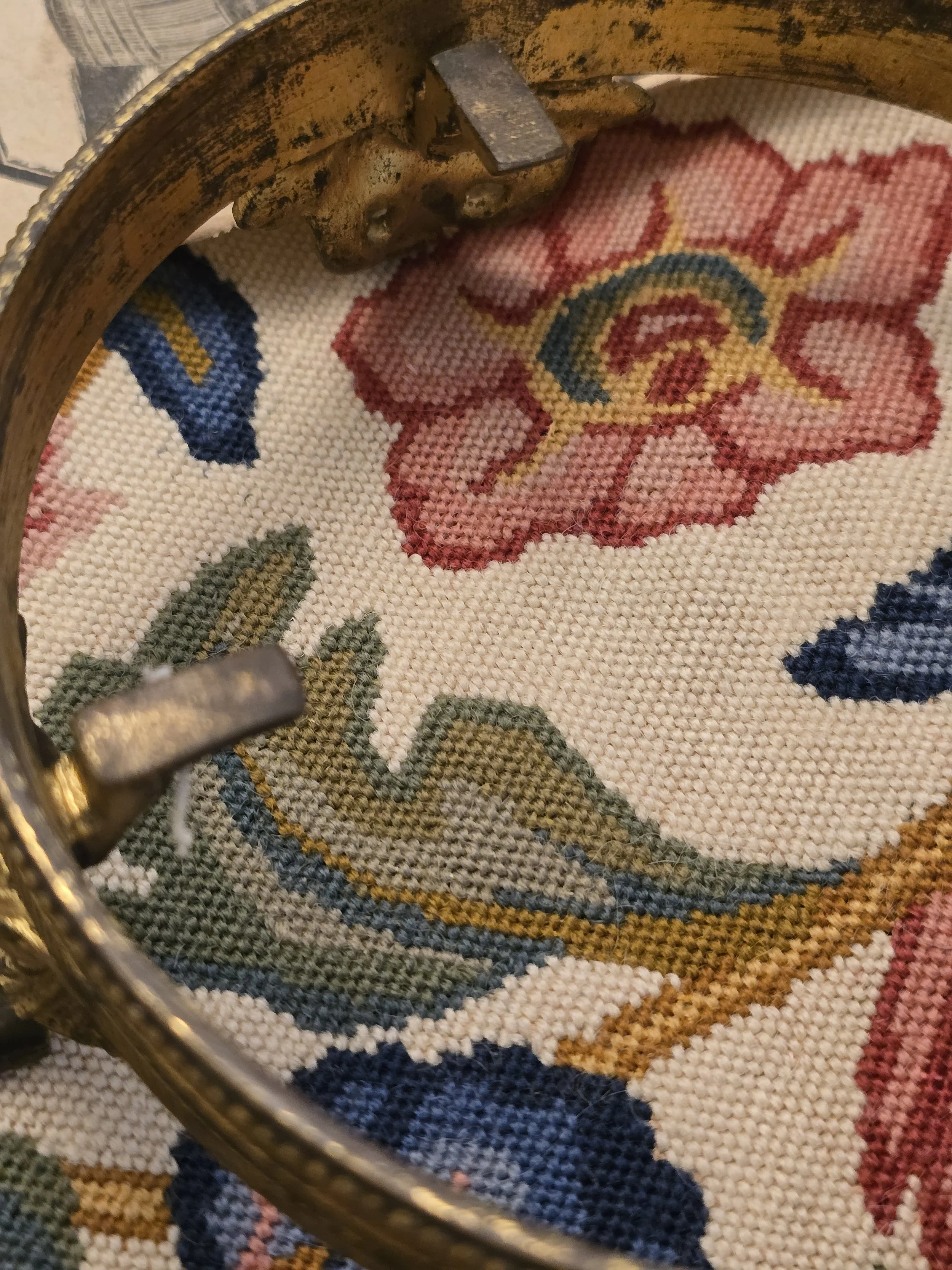 Close-up of the ornate circular metal stand showing its patterned rim, feet and natural patina.