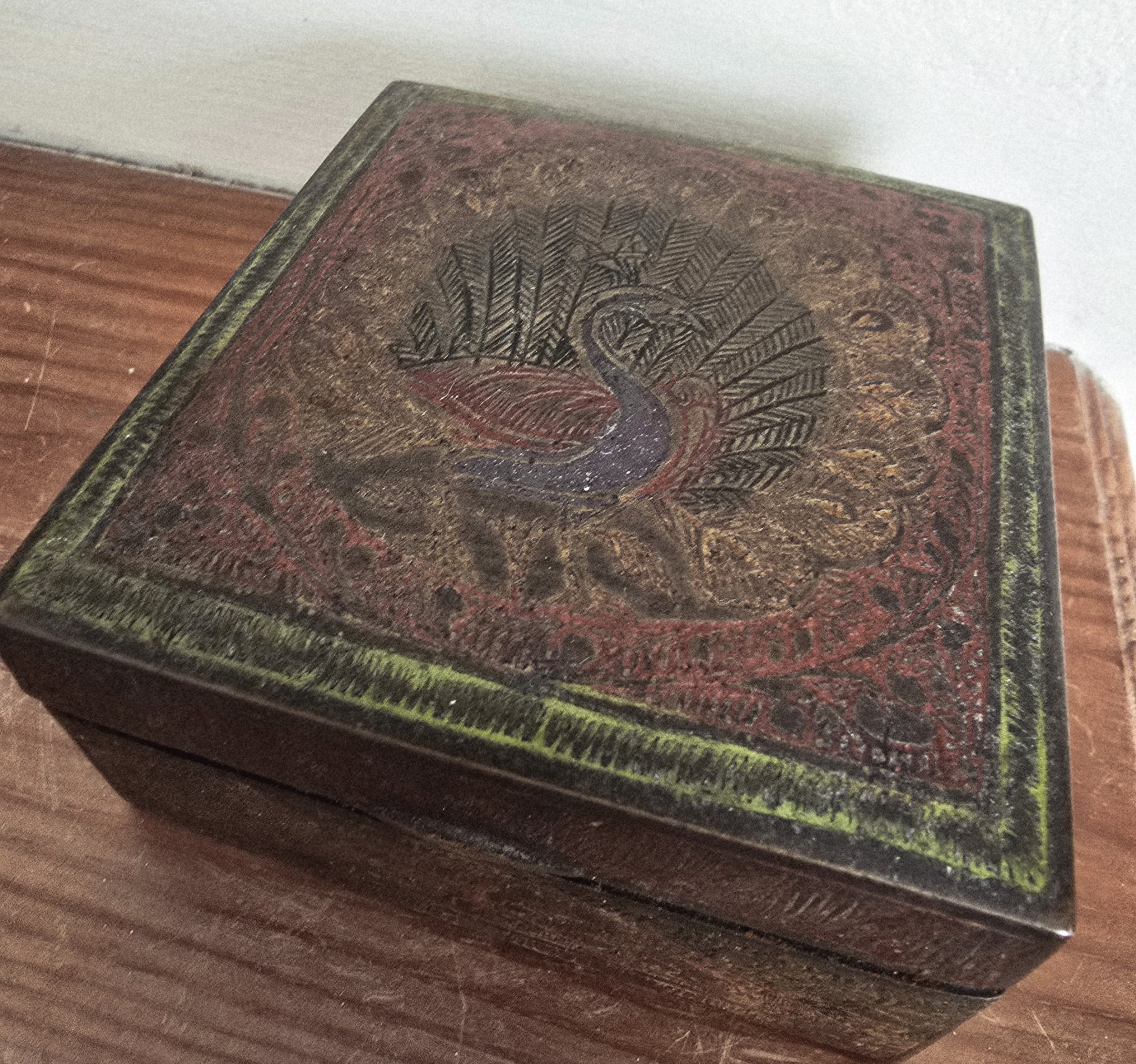 Hand-painted folk design on worn red copper box