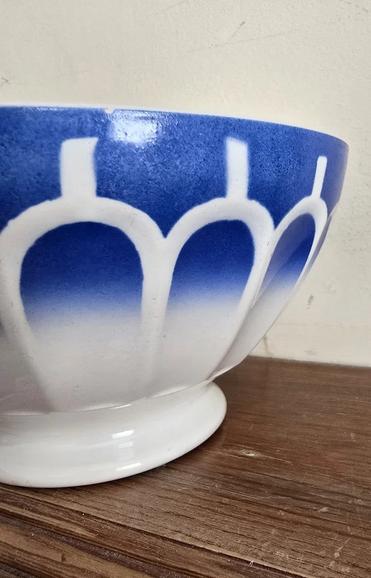 Side view of vintage Sarreguemines-style bowl in white and cobalt glaze