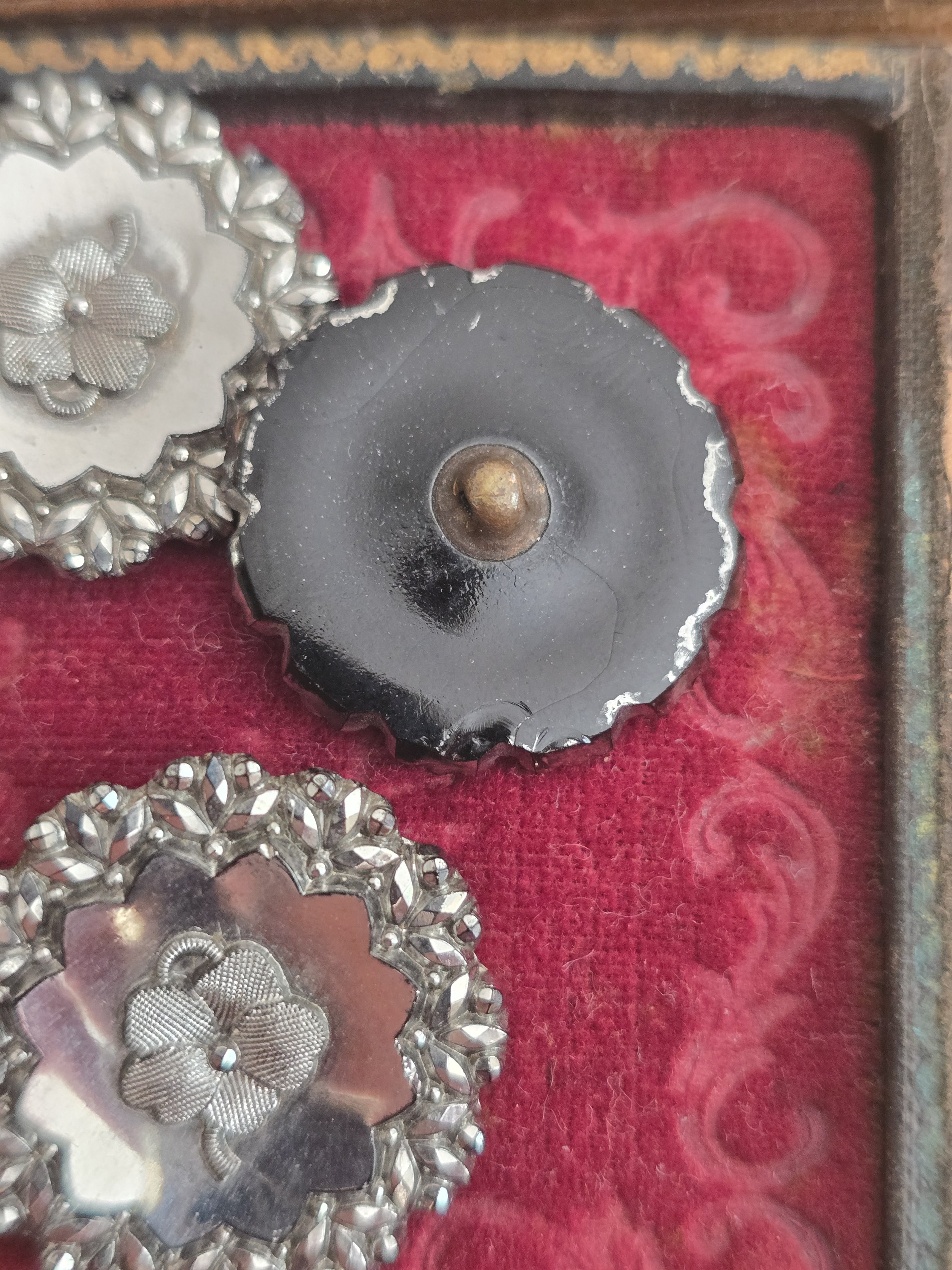 Reverse of an antique Victorian pressed steel button showing original black japanned back and soldered shank.
