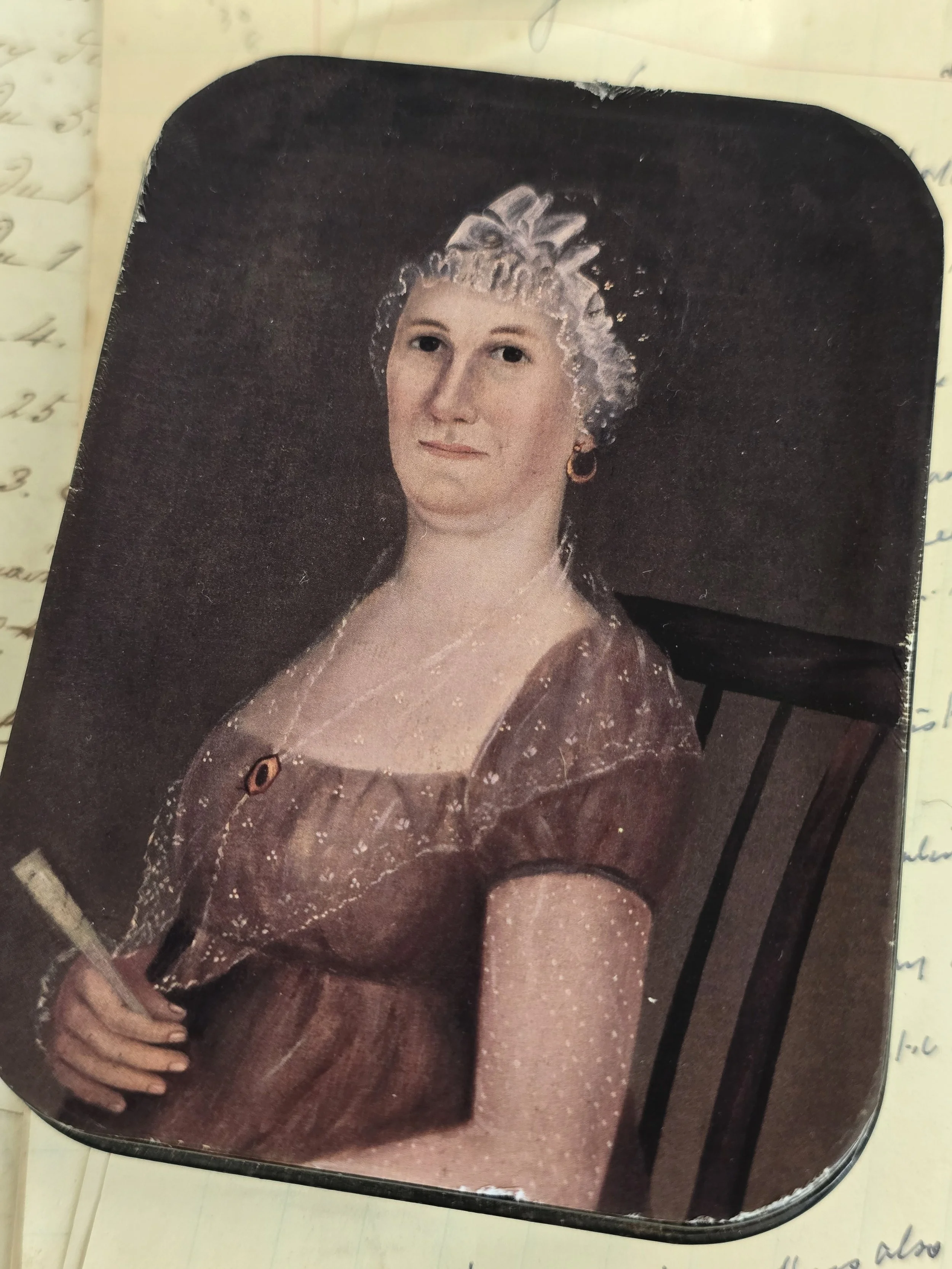 Distressed portrait tin featuring early American folk art style imagery.