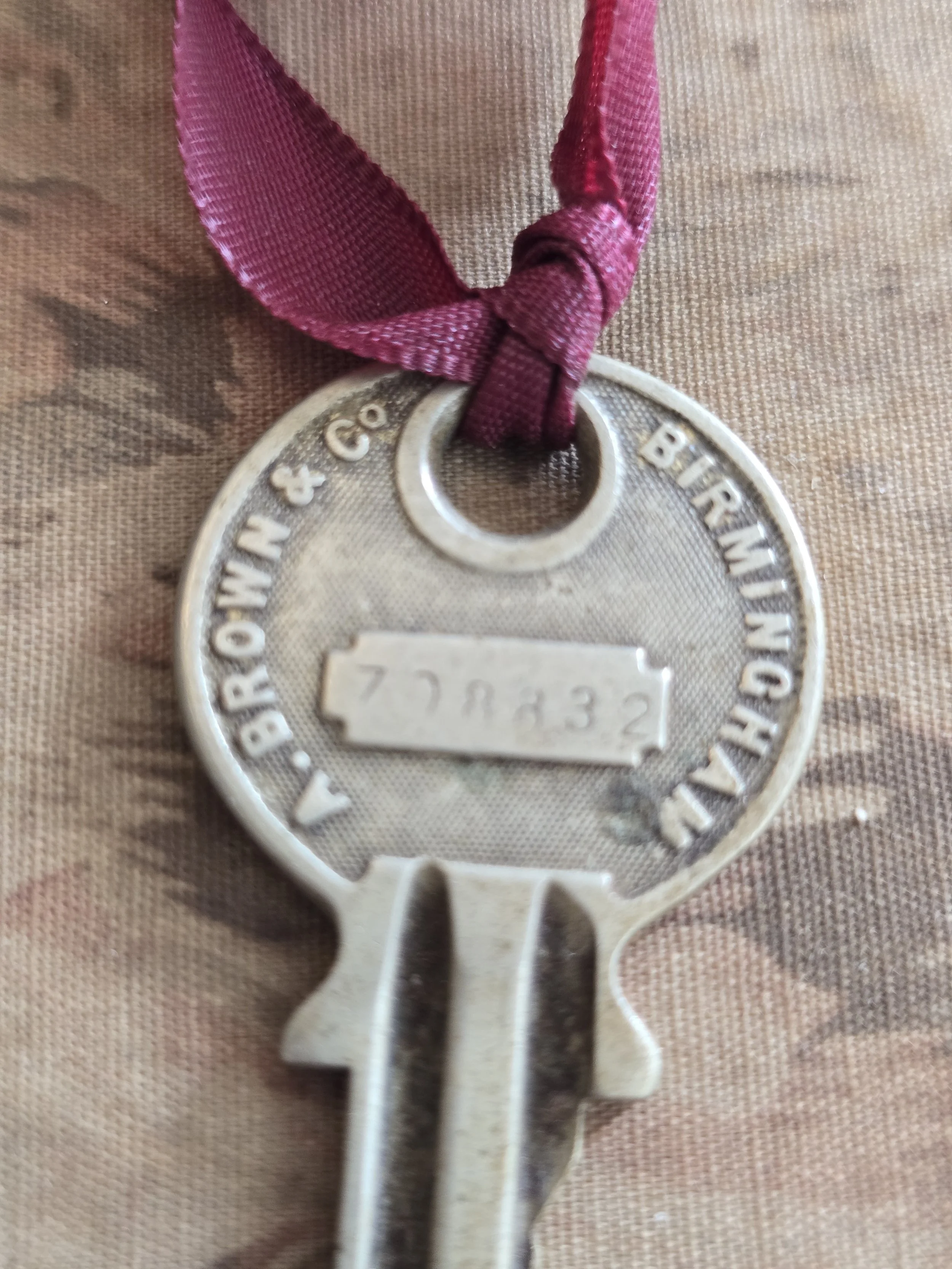 Detail of vintage industrial key with worn patina and ribbon.