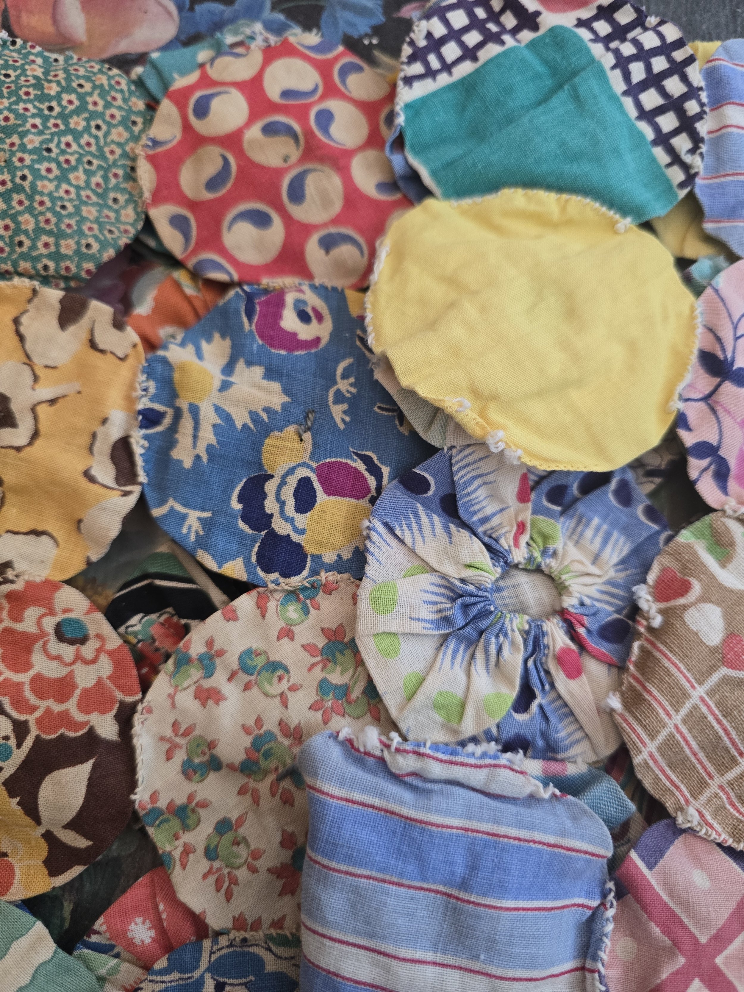 Vintage cotton yo-yo quilt components in floral, striped and checked fabrics.
