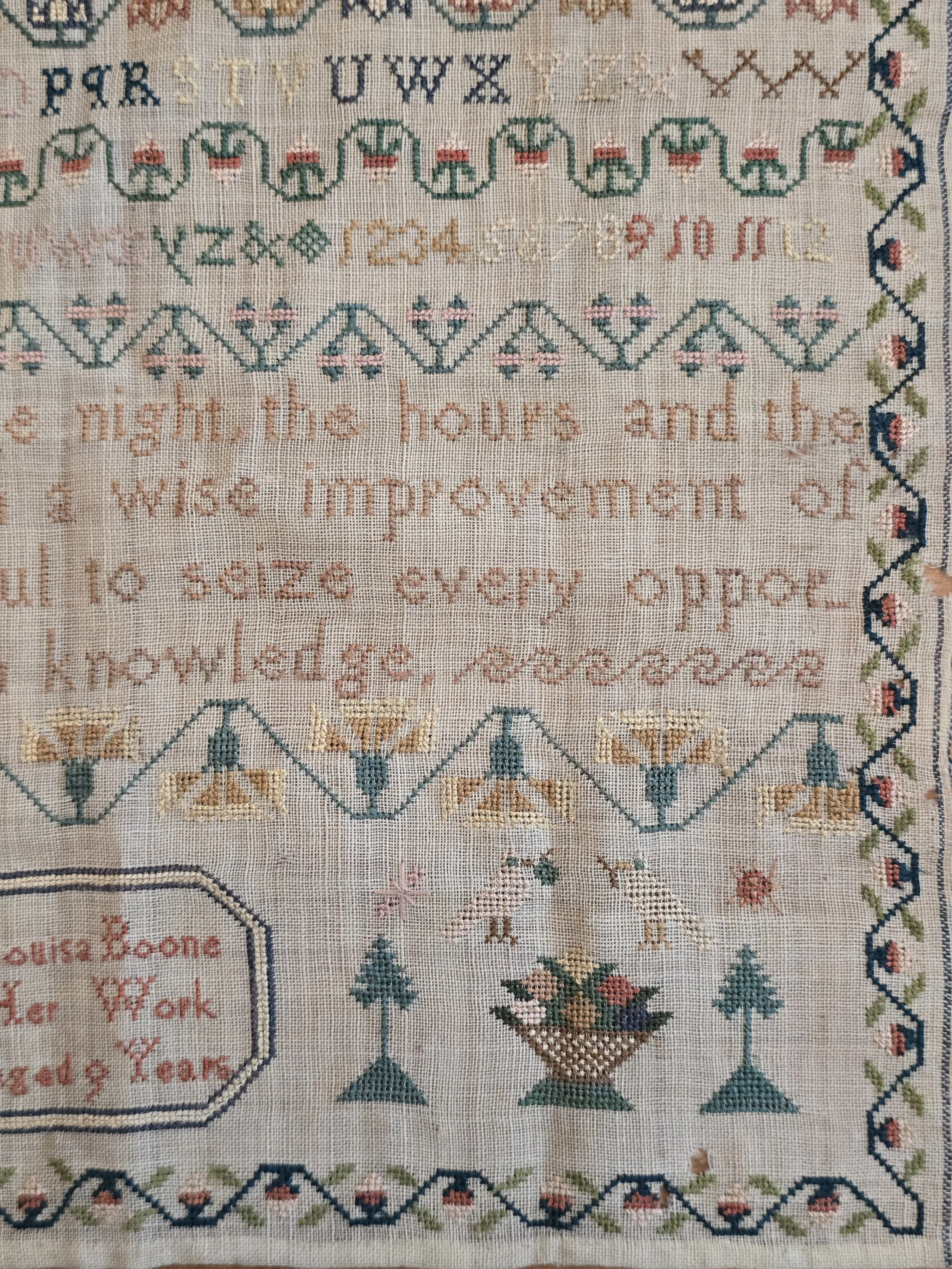 Early 19th century schoolgirl sampler embroidered by Louisa Boone aged 9 years with alphabets, birds, baskets and decorative borders on linen.