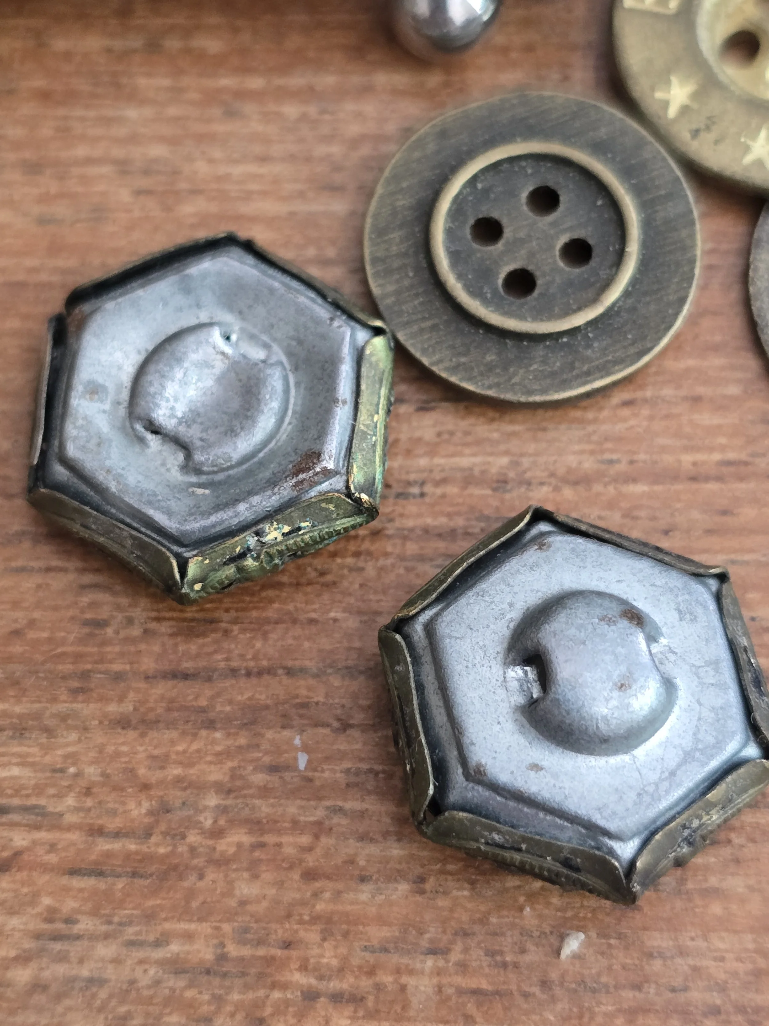 Reverse of antique hexagonal metal buttons showing original loop shanks.