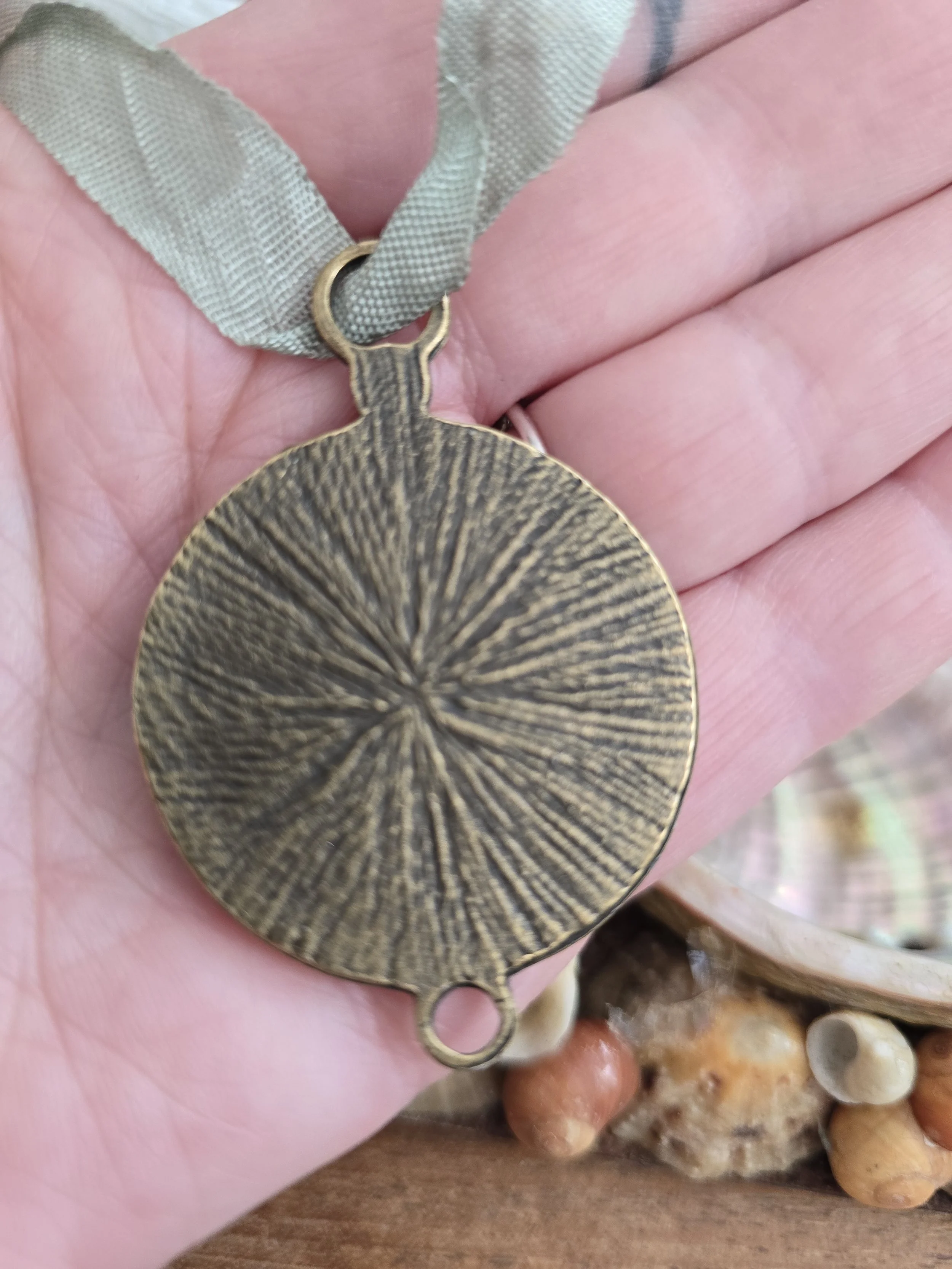 Reverse of the 4 cm brass-toned portrait setting showing its textured radiating design and aged finish.