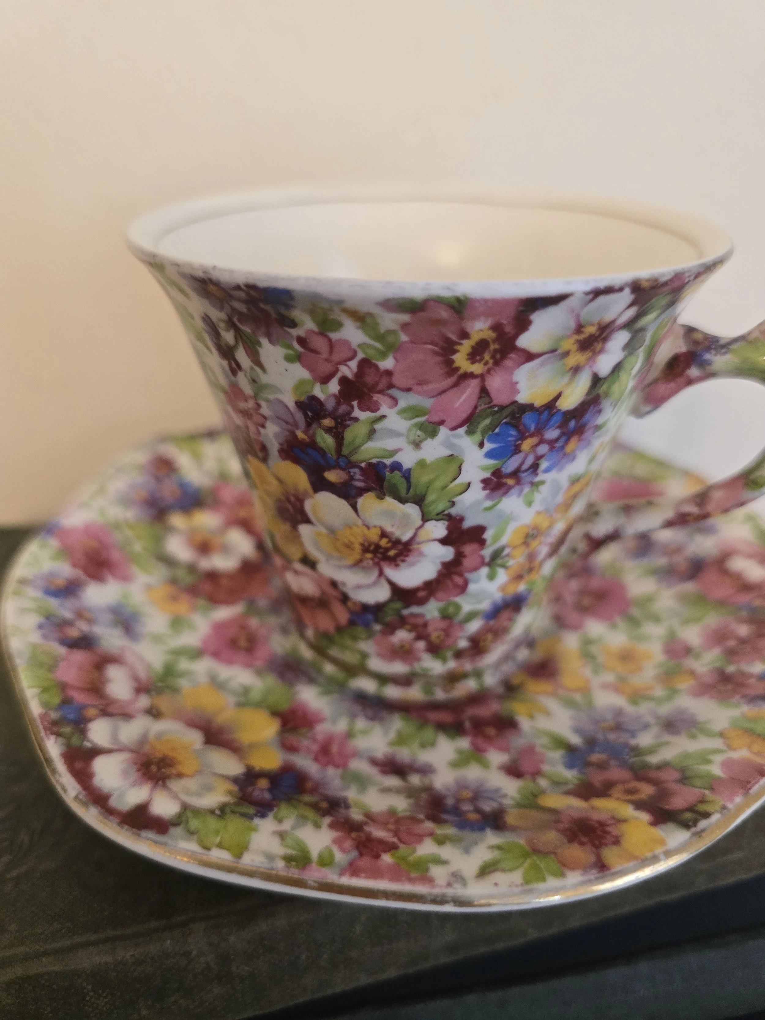Close view of Royal Winton chintz teacup and matching saucer featuring dense multicoloured floral print