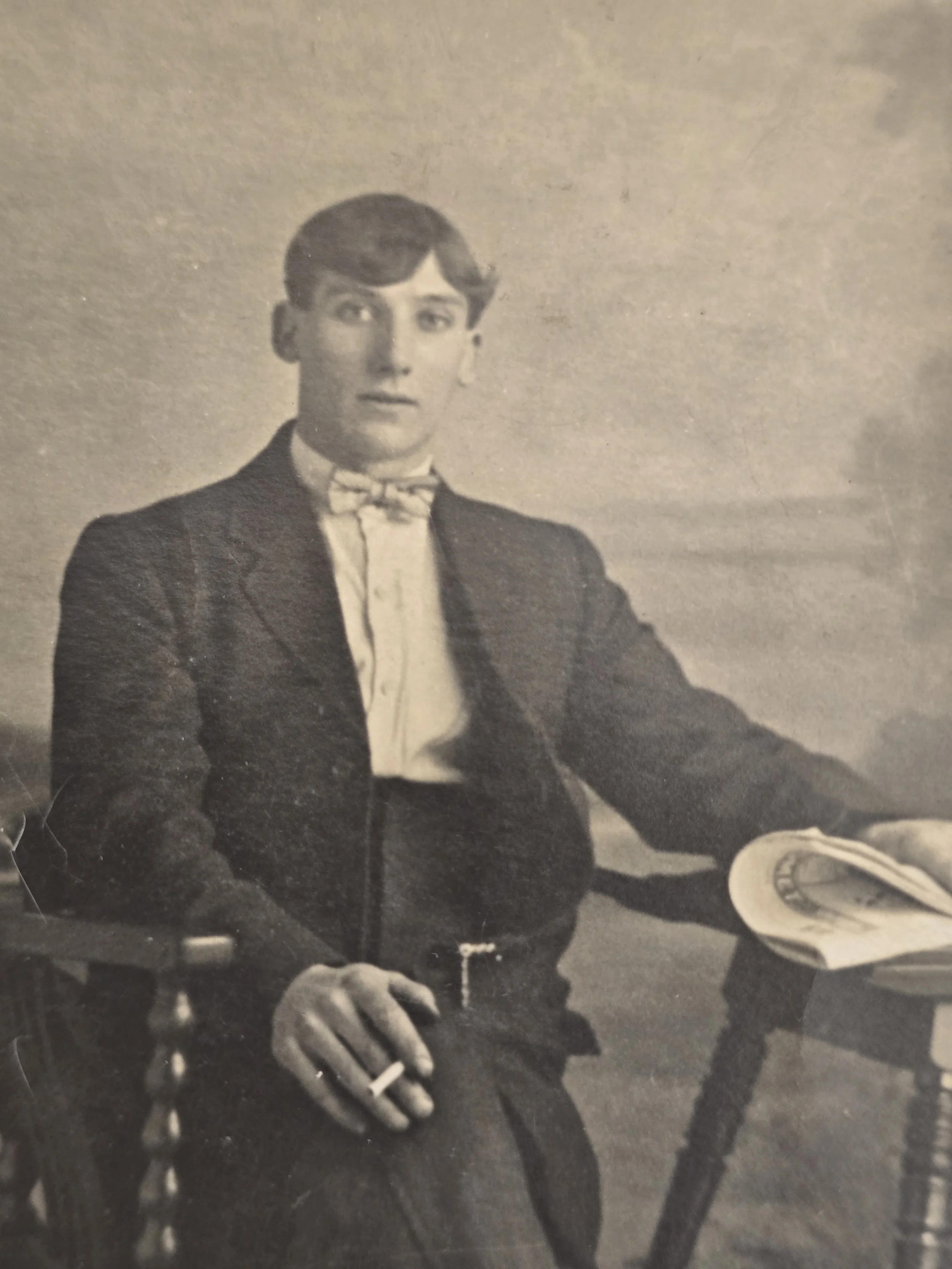 Vintage Gale’s Studios portrait showing a young gentleman holding a cigarette beside an open magazine.