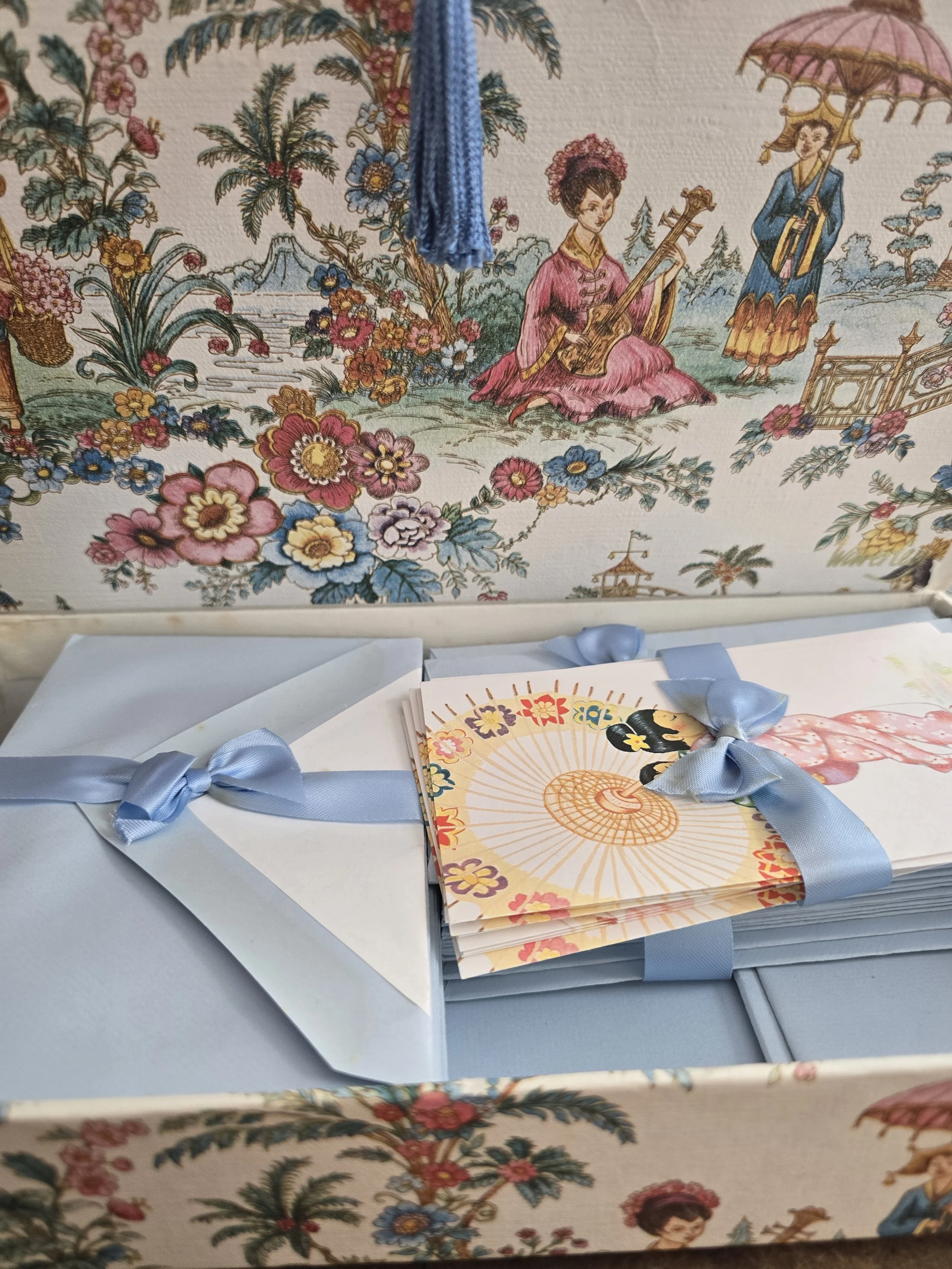 Vintage illustrated notelet showing a Japanese woman carrying a child beneath a parasol