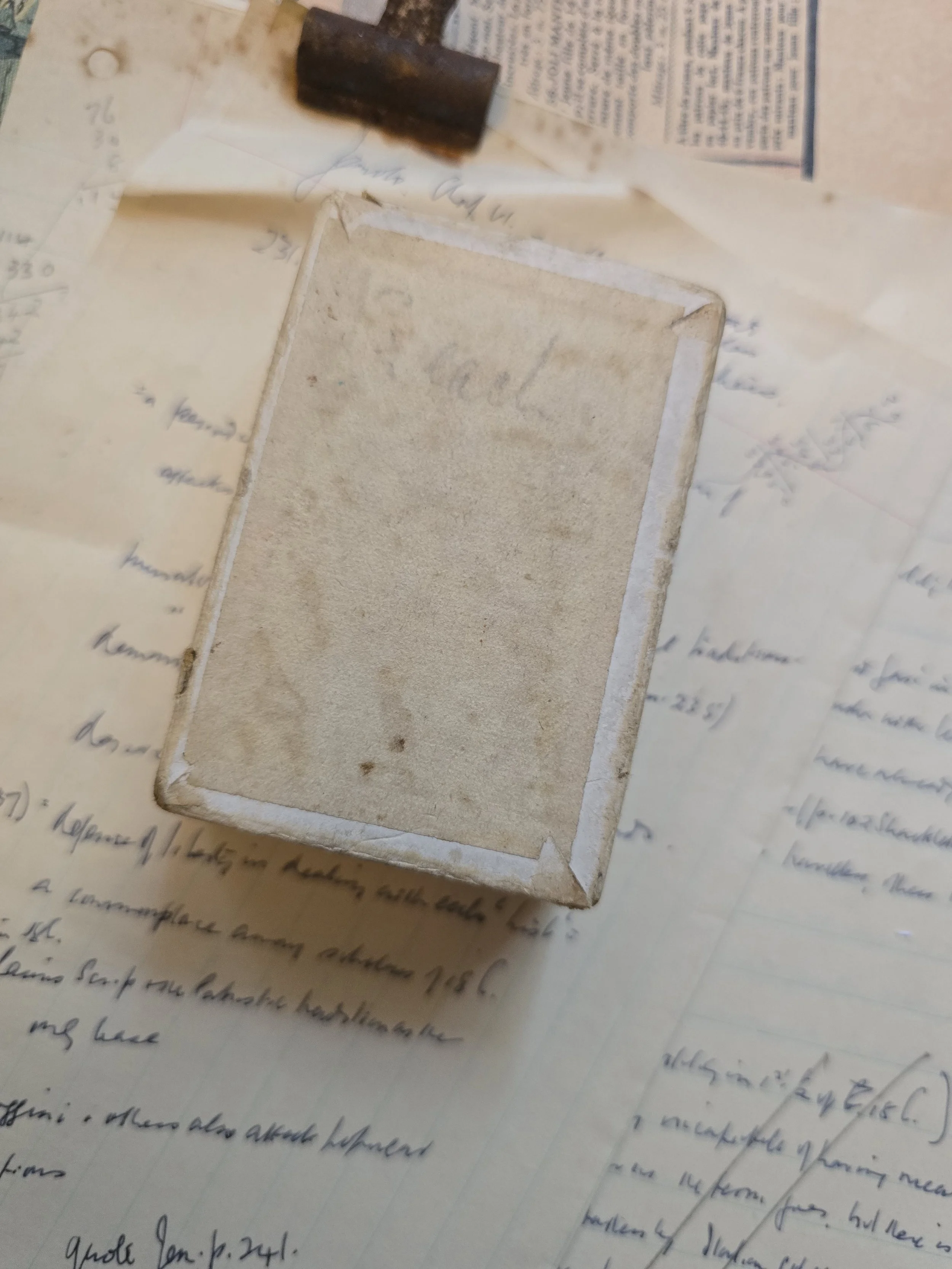 Underside of vintage card box showing original aged paper, marks and wear retained as part of its character.