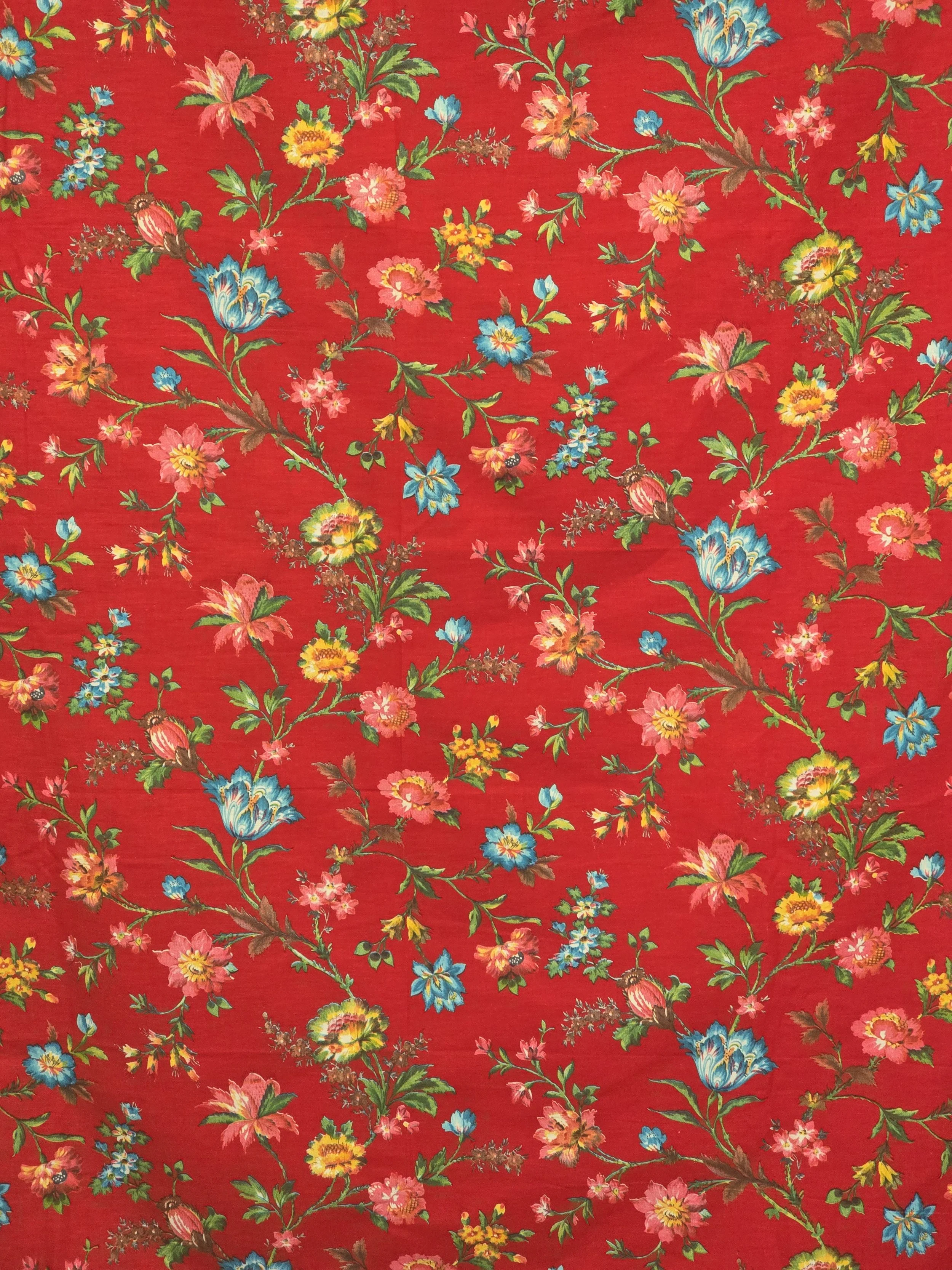 Large piece of red vintage floral fabric with turquoise blue, pink, yellow and green flowers.