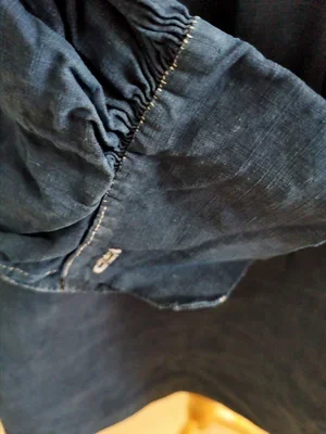 Shoulder pleat detail showing hand stitches on antique biaude.