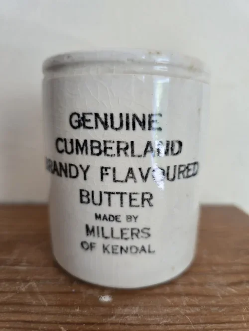 front view of antique cumberland butter jar with black text