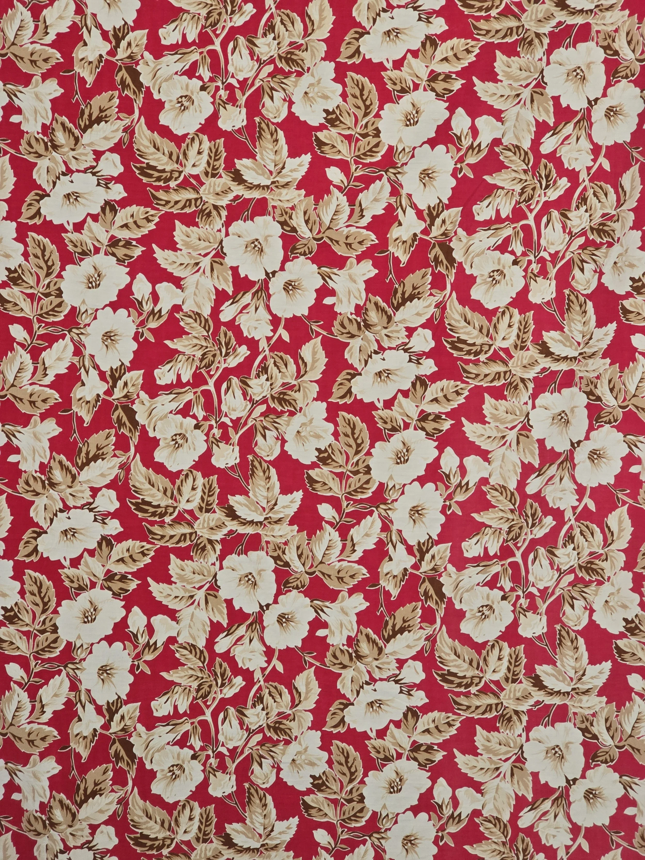 Bold vintage floral textile with repeating cream flowers on raspberry background