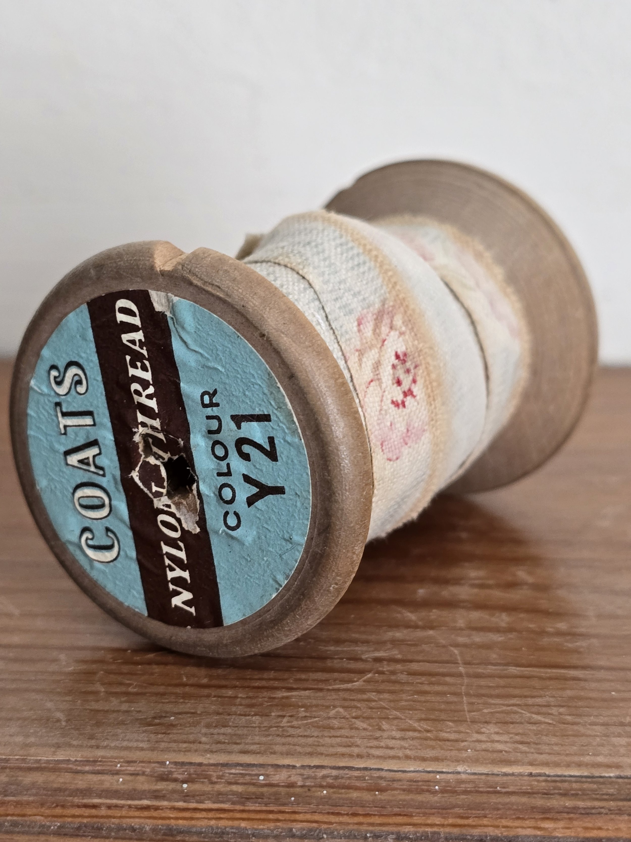 vintage spool with antique fabric, showing decorative label